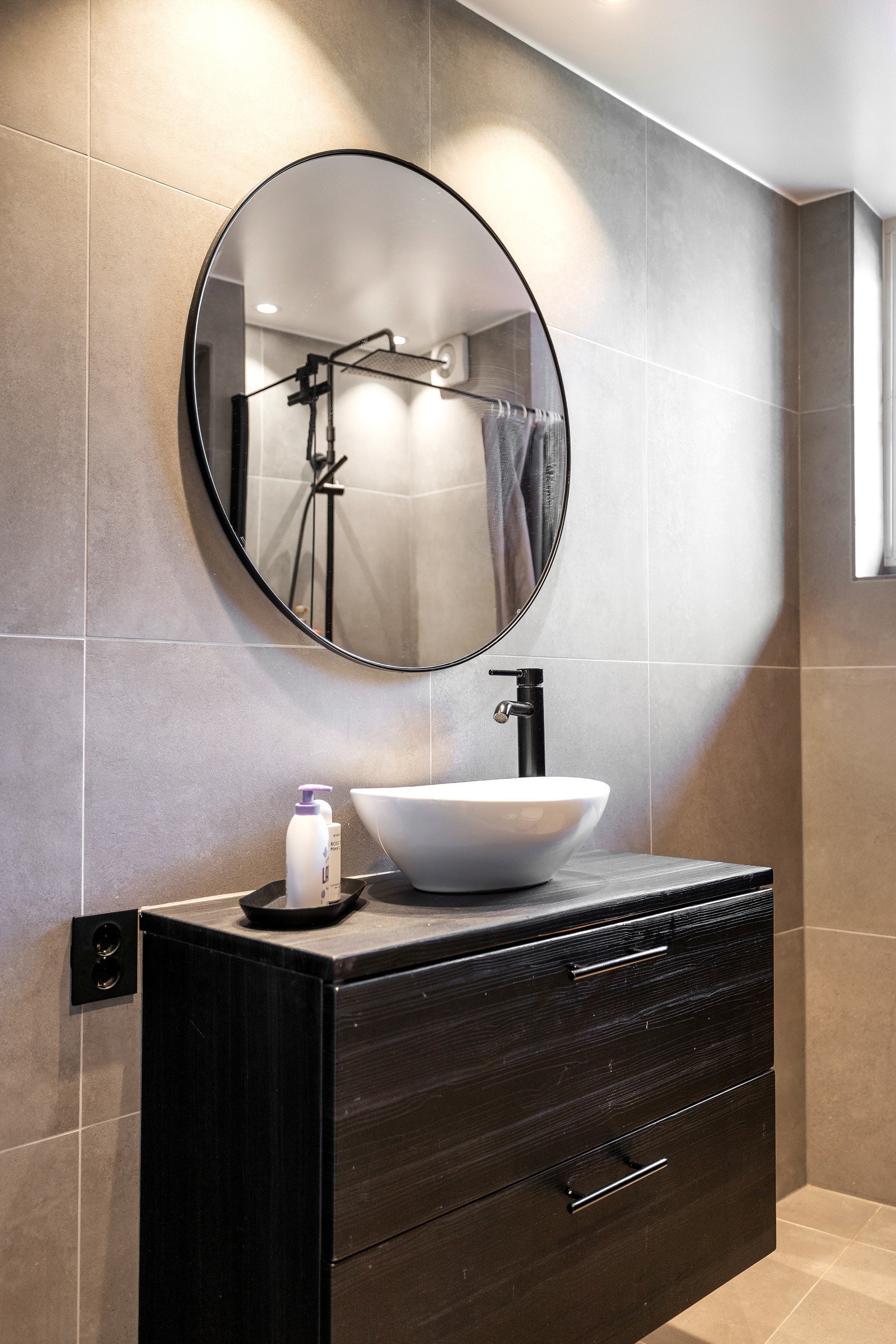 Badet har moderne fliser og stilfull, mørk innredning. Galleribilde