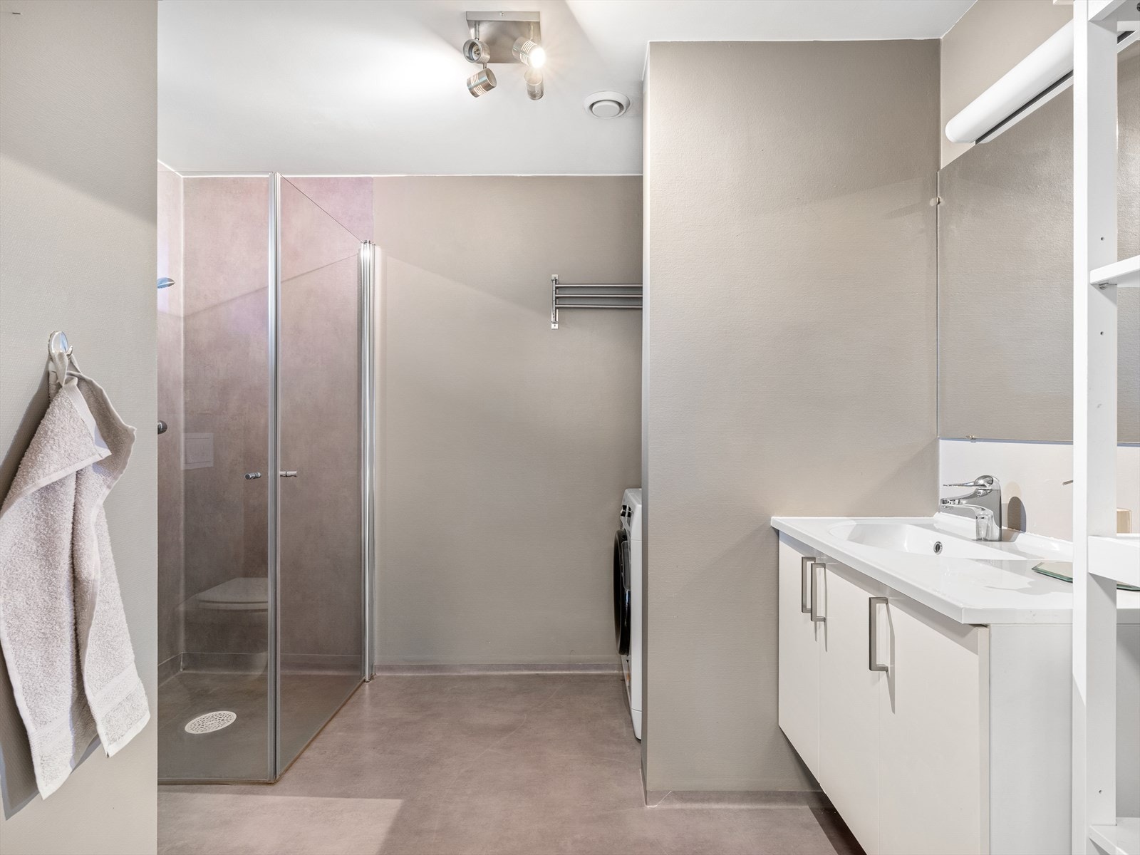 Romslig bad med servant, veggmontert wc, dusjvegger i hjørne Galleribilde