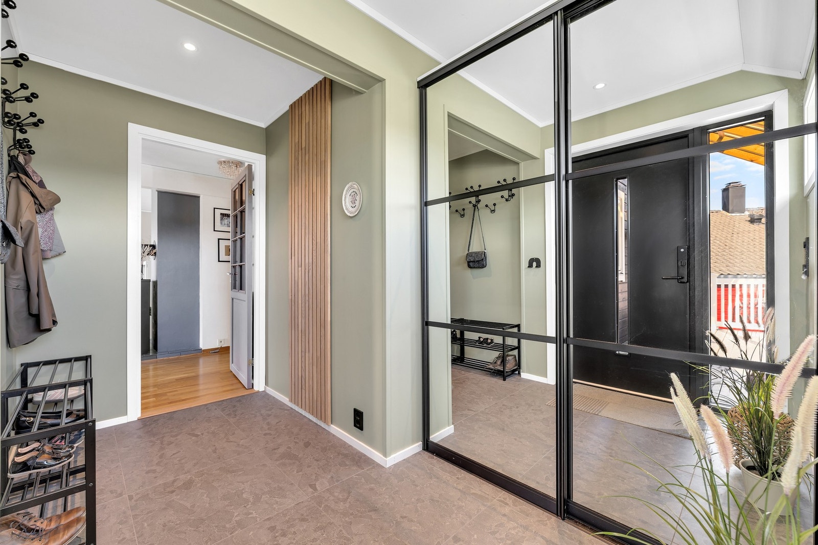 Moderne og ryddig entré med flislagt gulv og stor skyvedørsgarderobe m/speilfronter. Varmekabler i gulv. Galleribilde