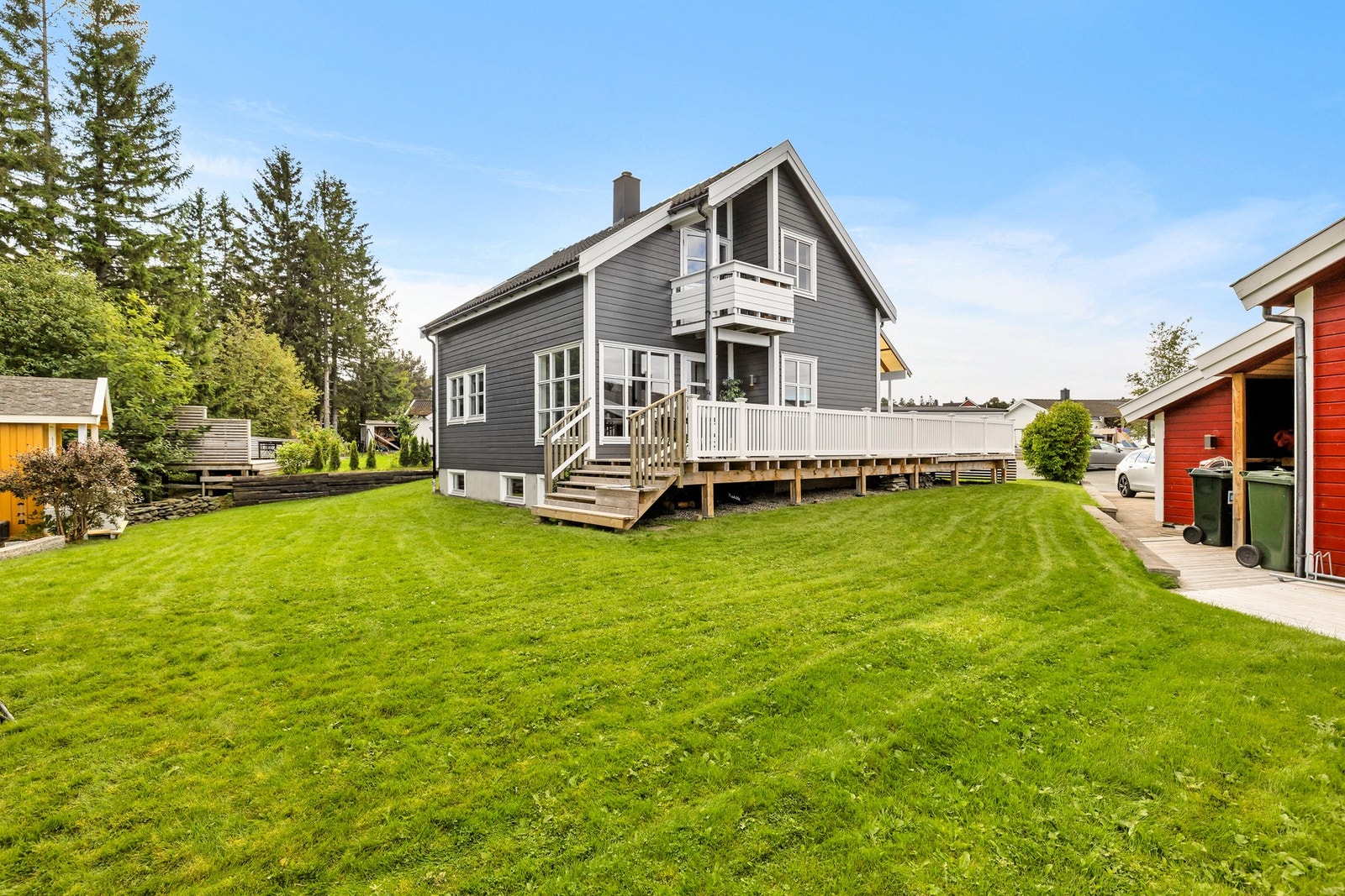 Boligen er omkranset av en flat og grønn plen Galleribilde