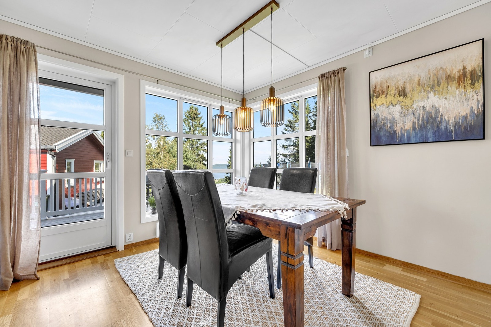 Spisestuen har flott utsyn mot grønne omgivelser og sjøgløtt, samtidig som terrassen forlenger rommet på sommerstid. Galleribilde