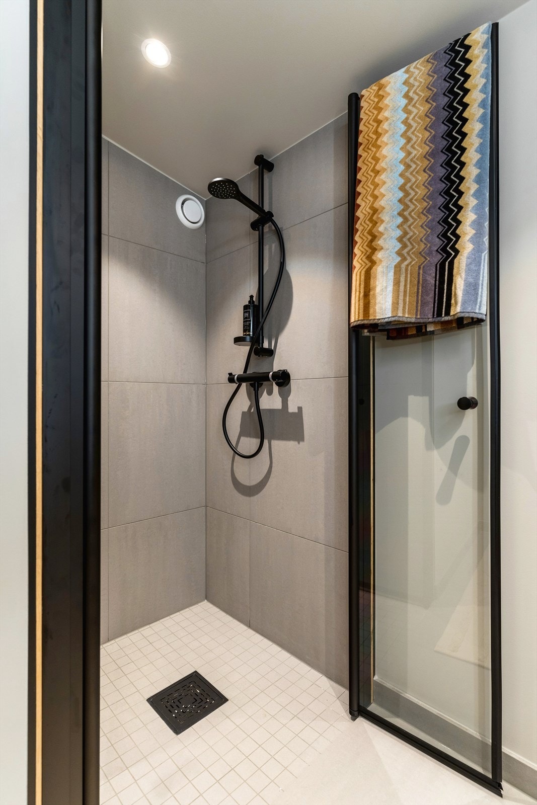 Moderne dusj med stilrent design og regndusj. Flislagte vegger og gulv gir et eksklusivt preg. Galleribilde