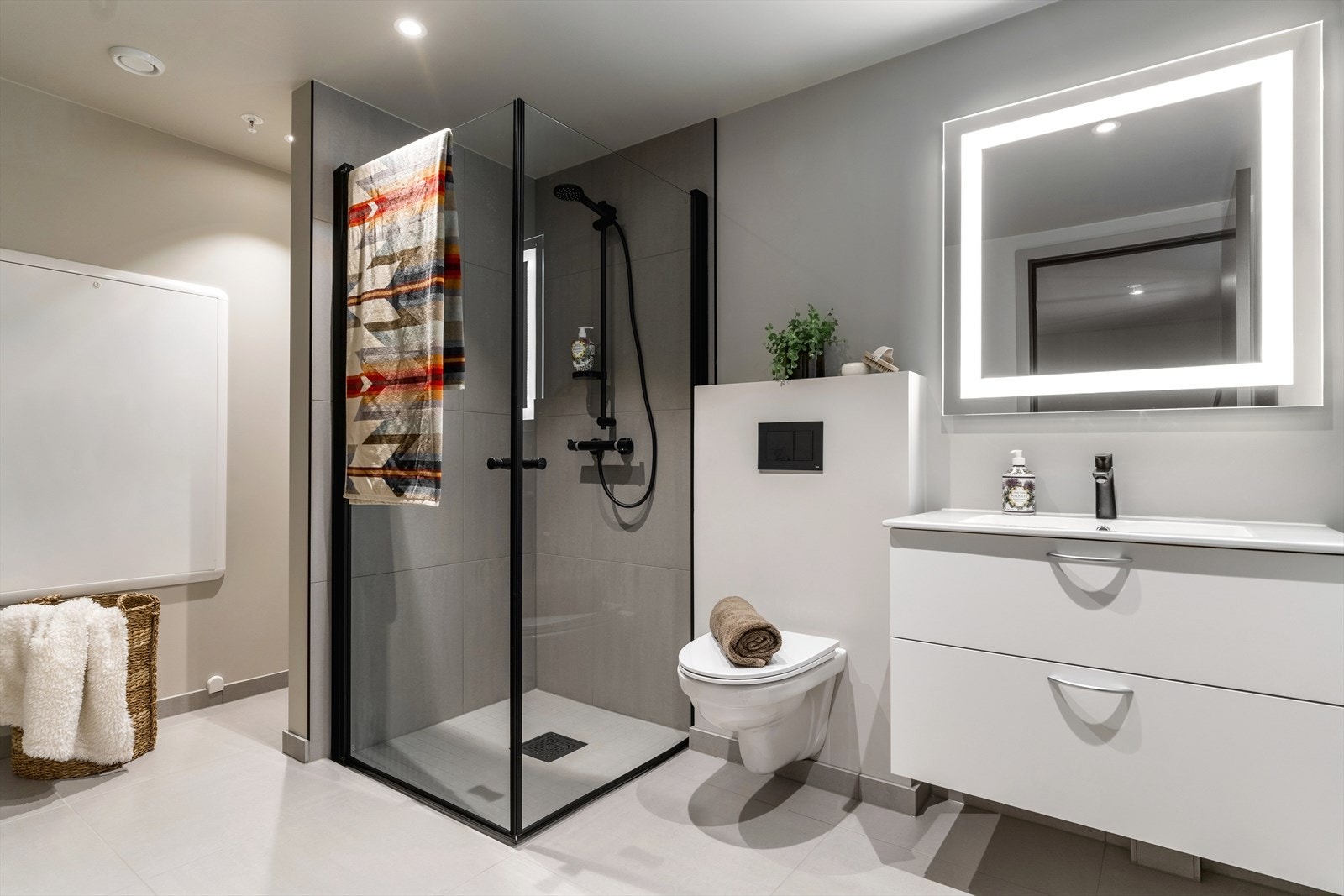 Moderne og romslig baderom med dusjhjørne, vegghengt toalett og stilfull belysning. Perfekt for en komfortabel og praktisk hverdag. Galleribilde