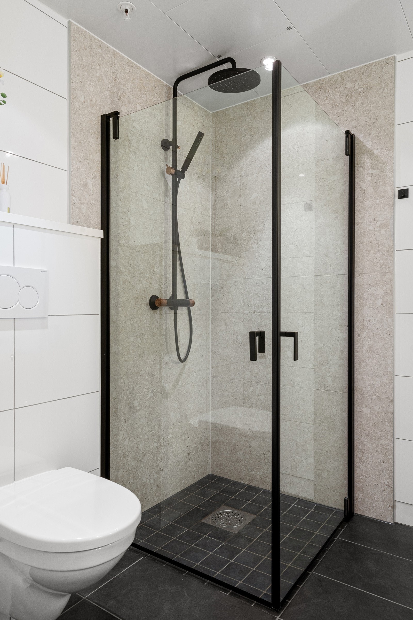 Dusjhjørne med regndusj og glassdører med sorte detaljer. Galleribilde