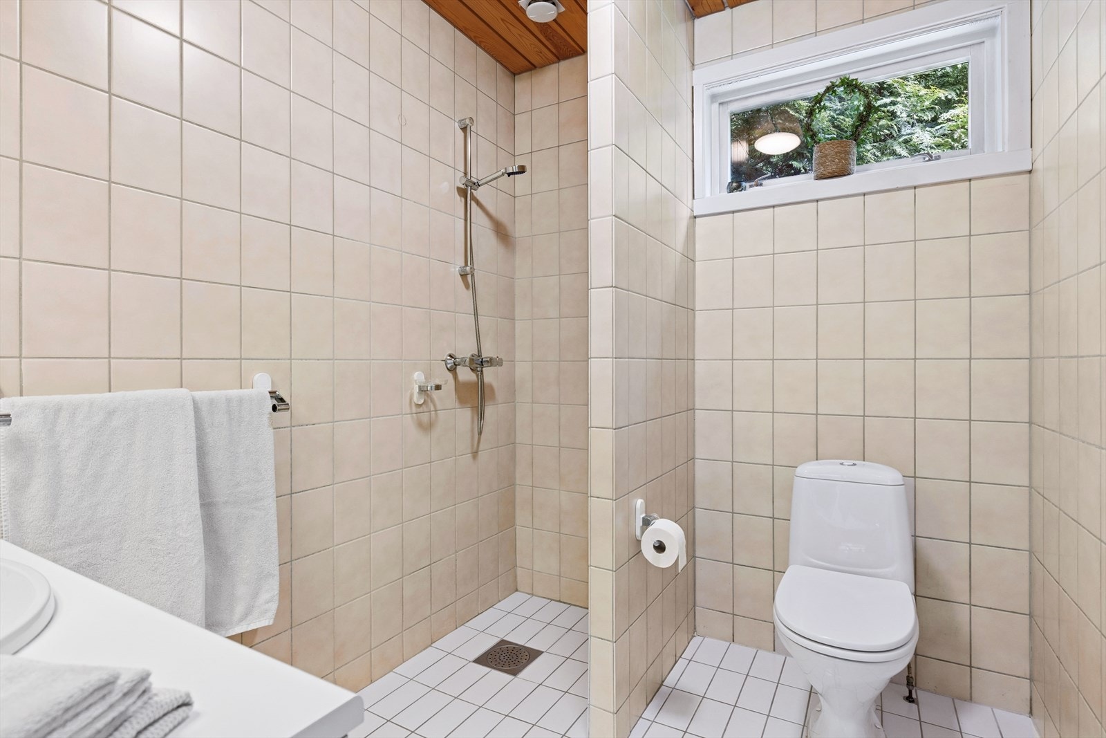 Dette badet er innredet med dusjhjørne, servant med skapinnredning og toalett Galleribilde