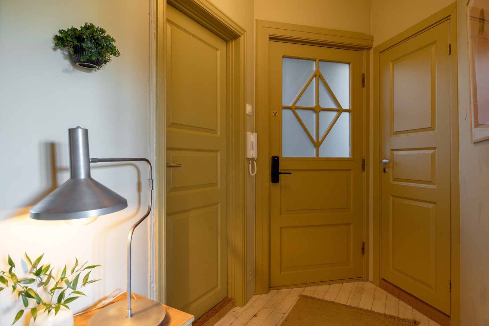 Leiligheten har en innbydende entré som ble pusset opp i 2025 - en smakfull og varm velkomst til et gjennomført hjem. Galleribilde