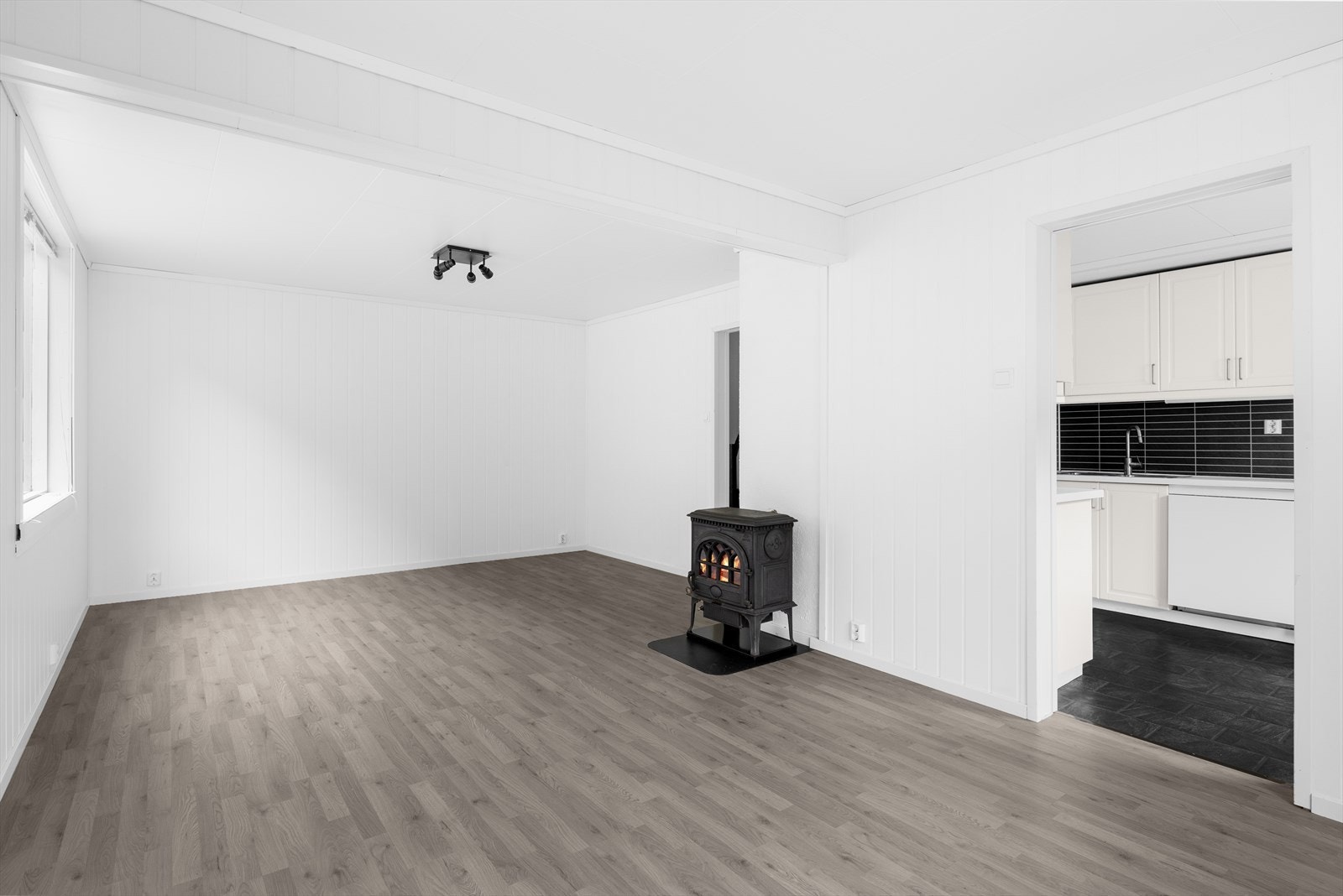 Romslig stue med plass til flere sittegrupper. Galleribilde