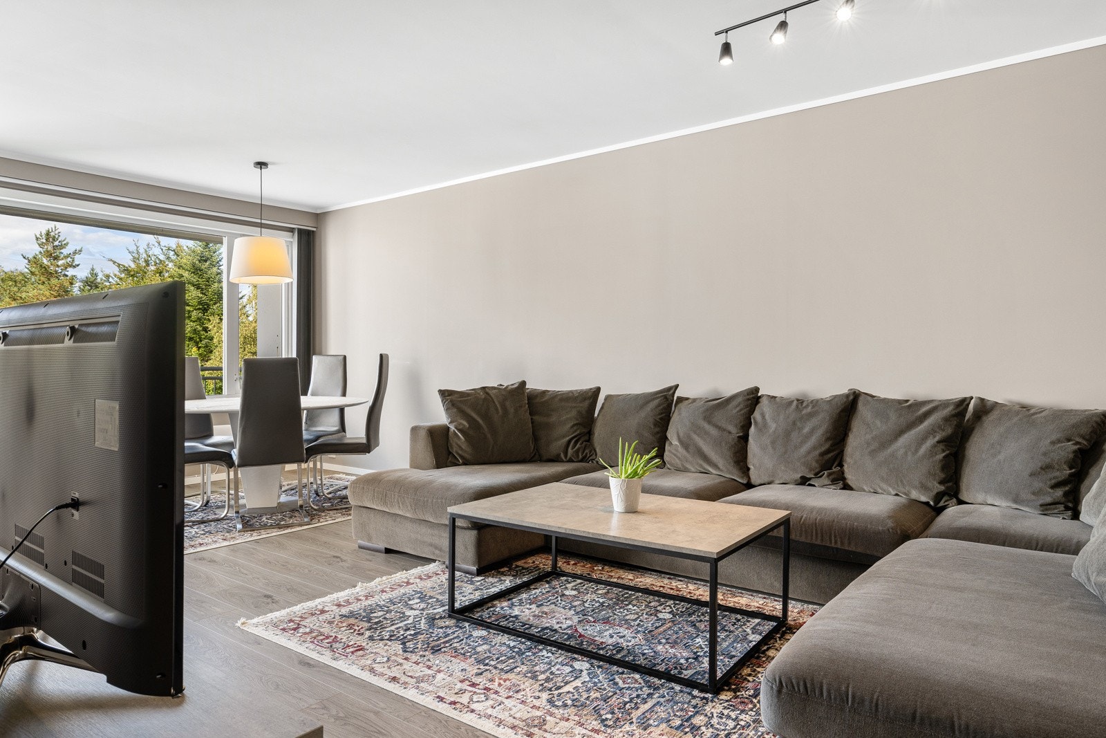 Stuen er romslig med god plass til både stor sofa og spisebord. Galleribilde