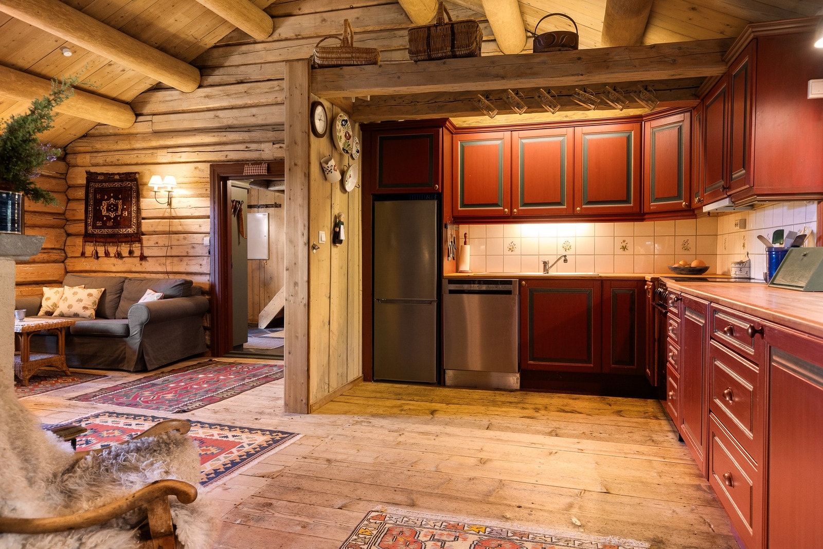 Kjøkkenet har et tradisjonelt preg med profilerte fronter i dype rødfarger og en heltre benkeplate som gir et rustikt uttrykk. Galleribilde