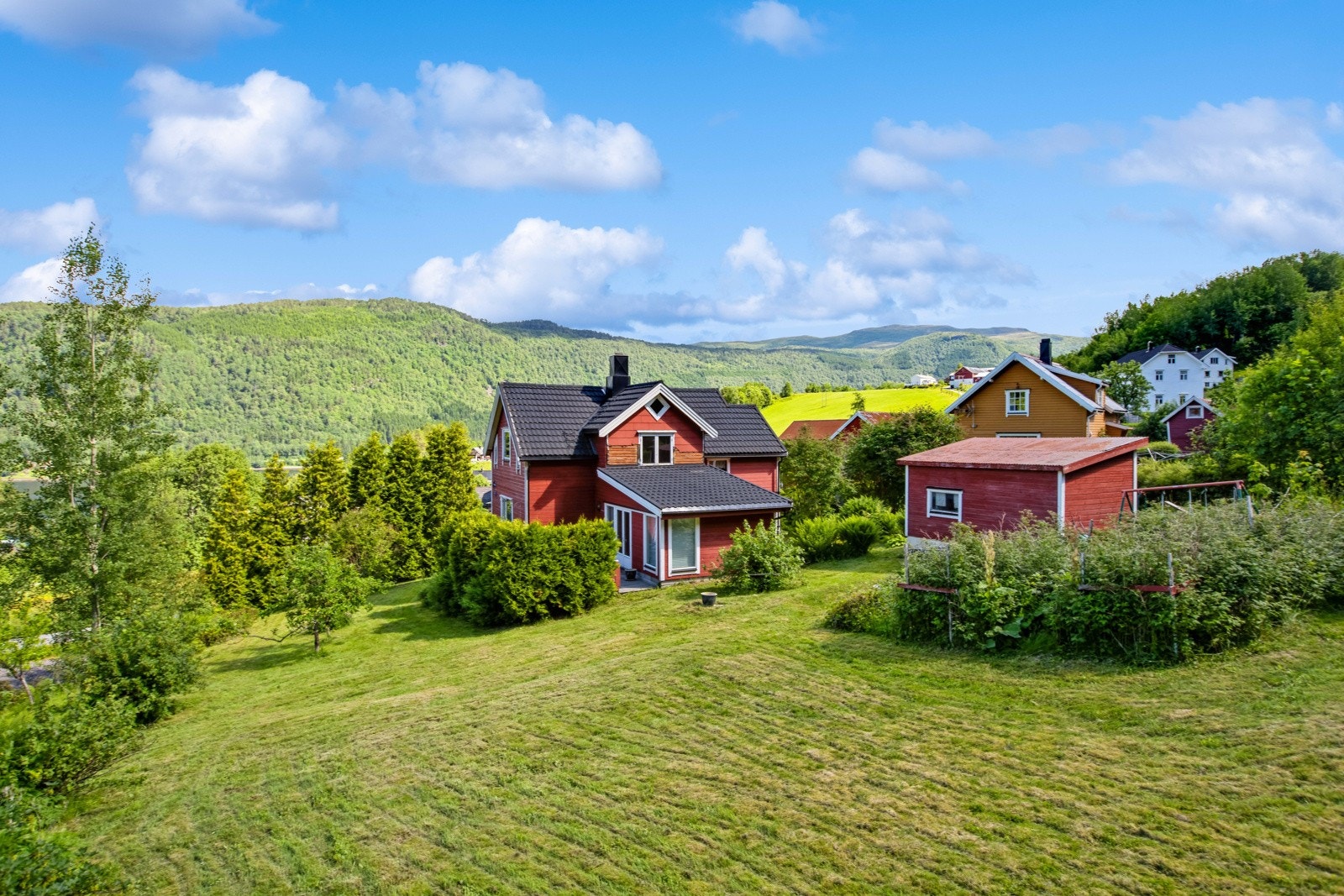 Boligen ligger på en stor og flott tomt i vakre omgivelser med nærhet til butikk, sjø og fjell. Galleribilde