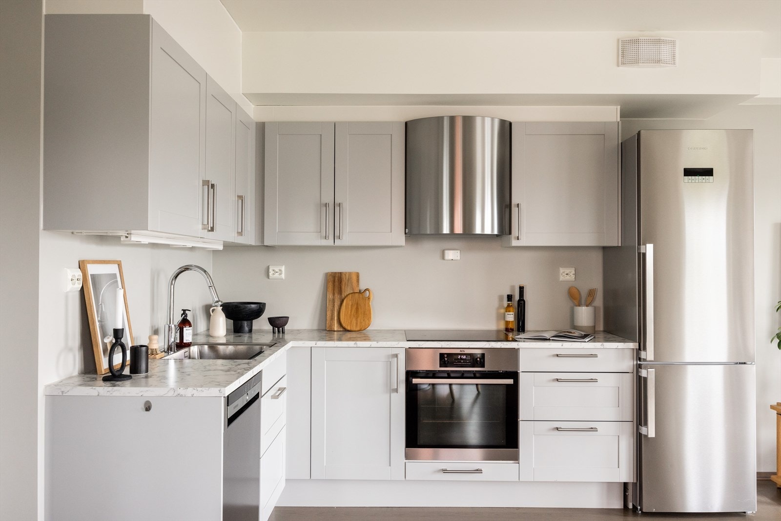 Stilren kjøkkeninnredning. Integrert oppvaskmaskin, platetopp og stekeovn, samt plass til kjøleskap. Mekanisk avtrekk. Galleribilde