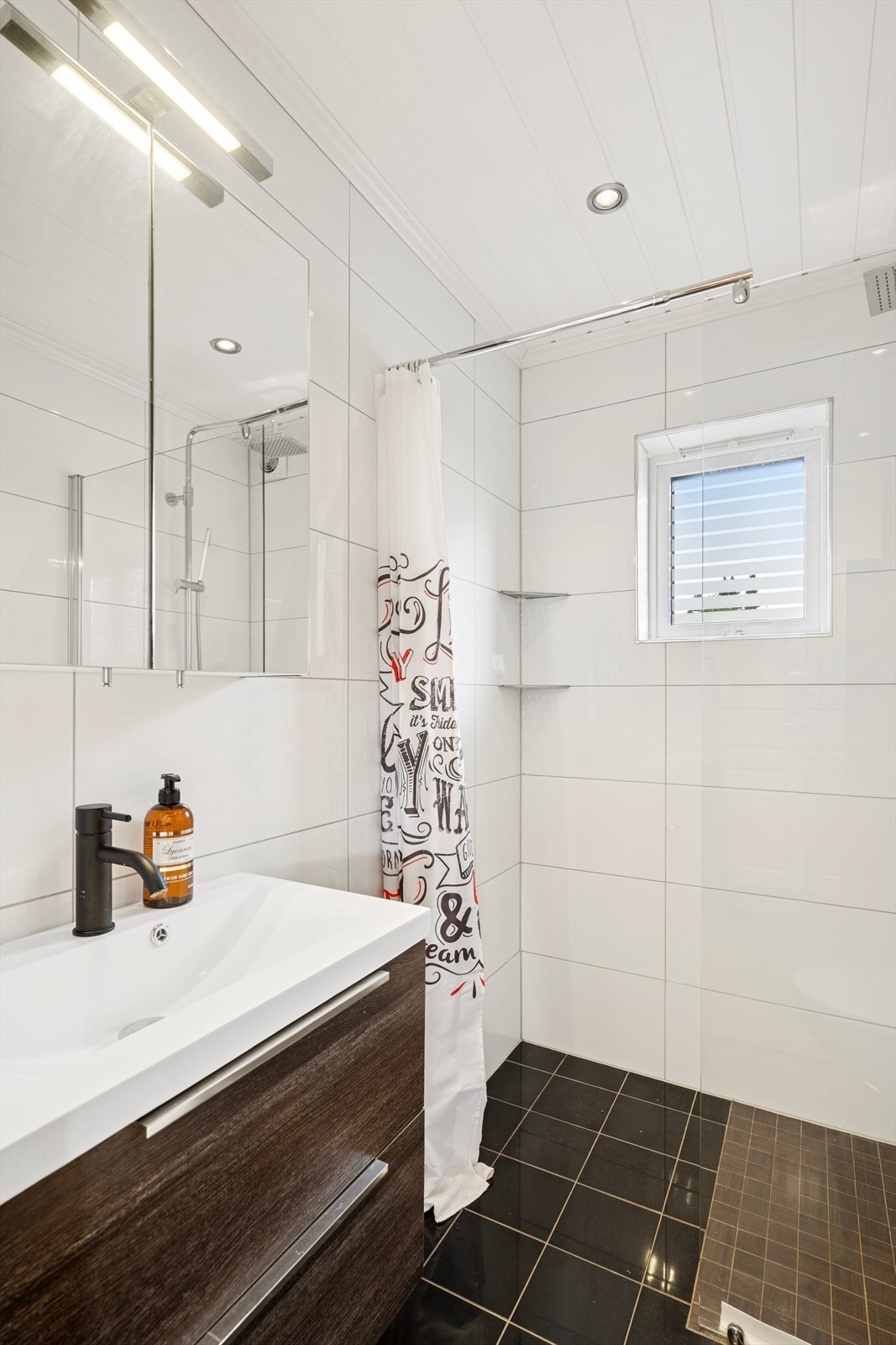 Flislagt bad med moderne innredning og dusjhjørne. Galleribilde