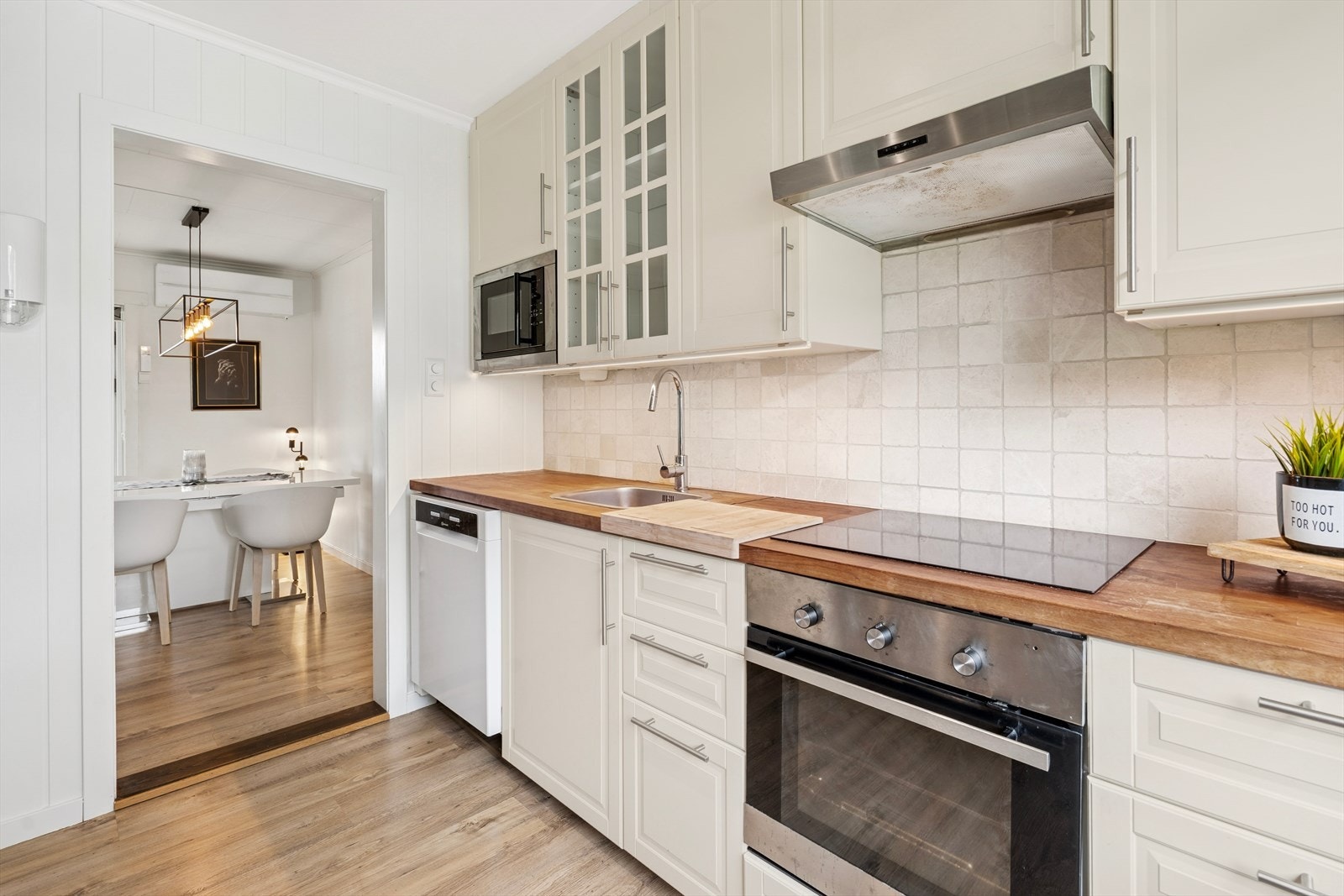 Klassisk kjøkken med hvite fronter og rikelig benkeplass. Galleribilde