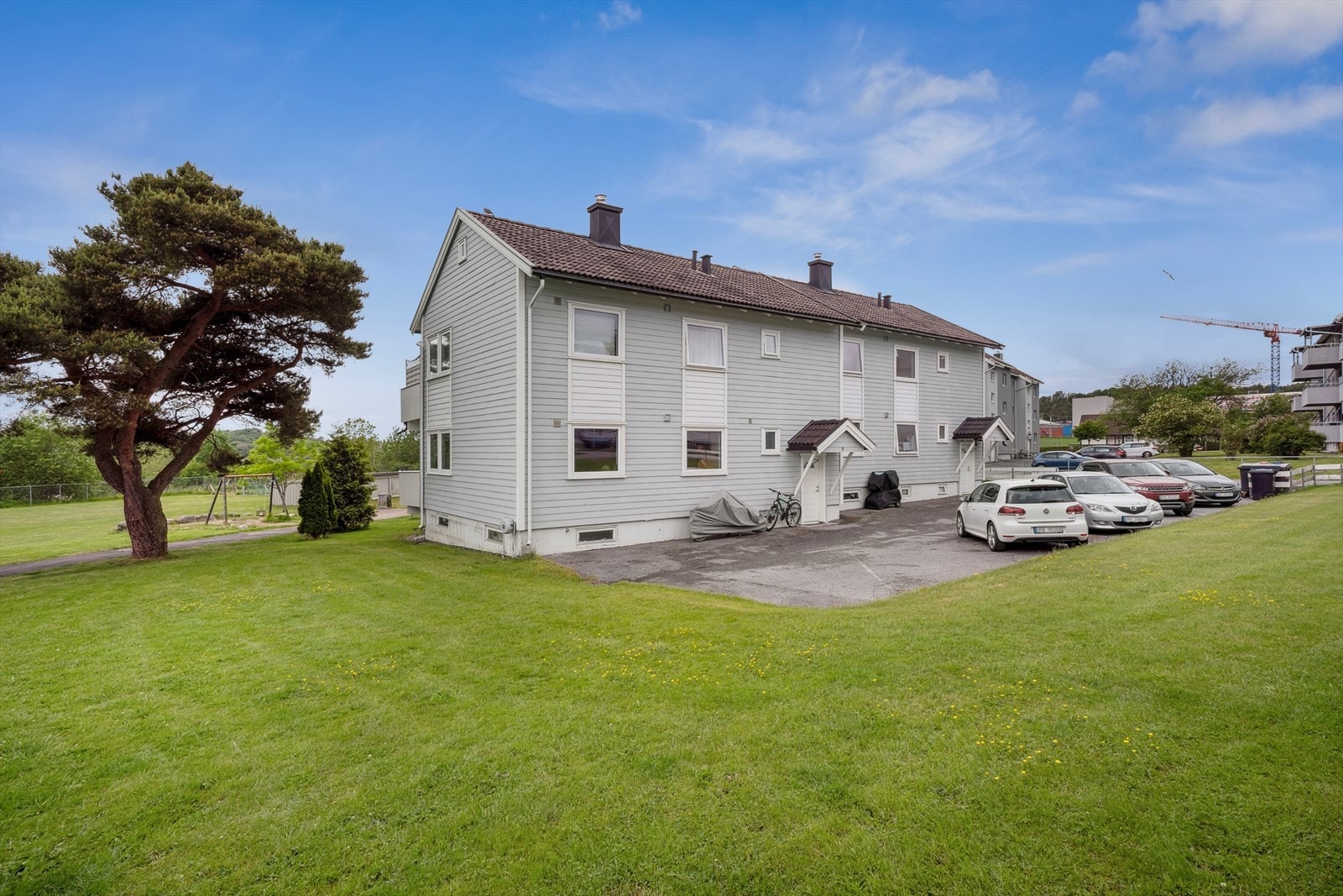 Byggets Inngangsside med parkering og plen rundt. Galleribilde