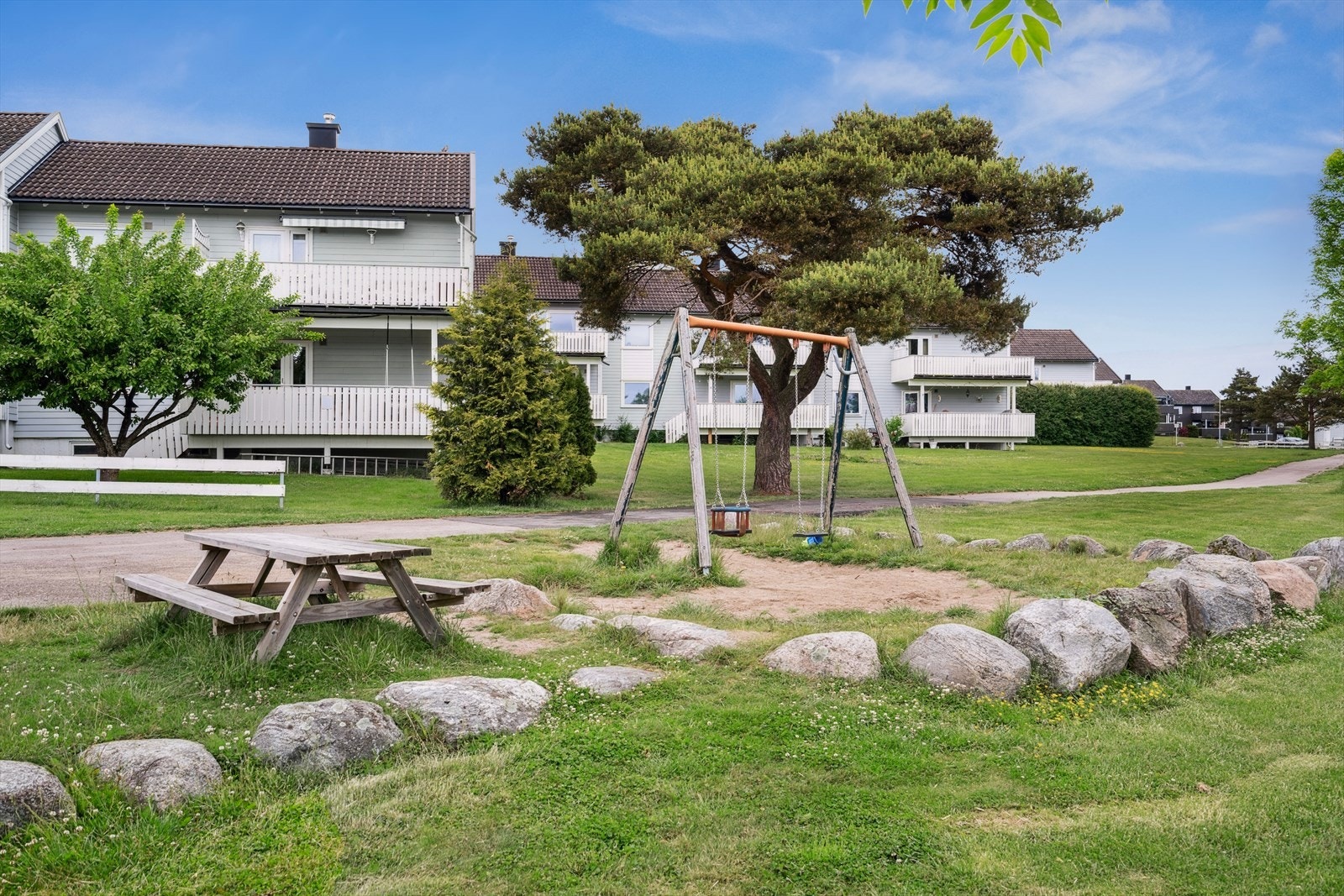 Koselig fellesområde med sitteplasser og plen. Galleribilde