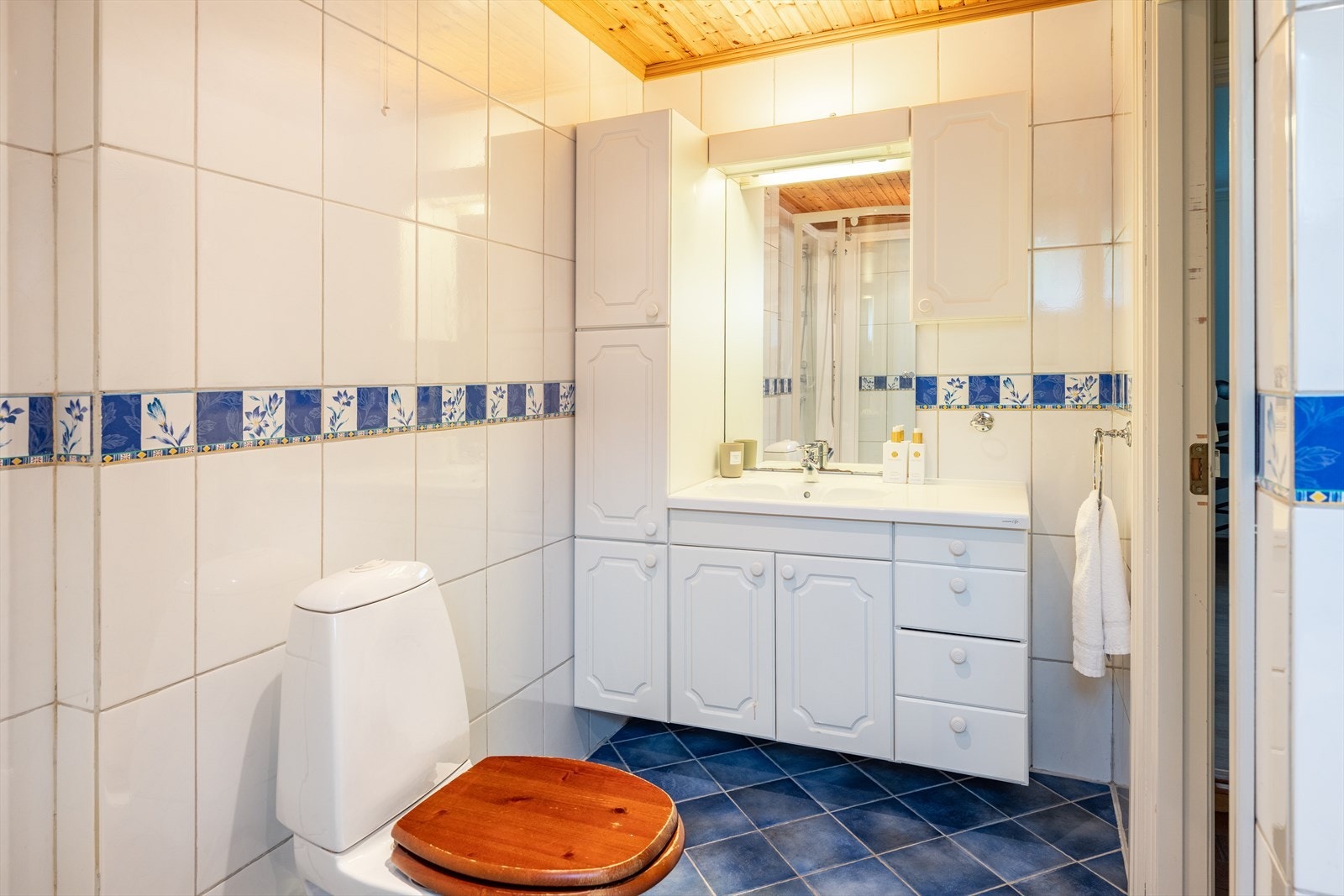 Badet er utstyrt med badekar, dusjkabinett, mekanisk avtrekk, servant, servantskap og WC. Galleribilde