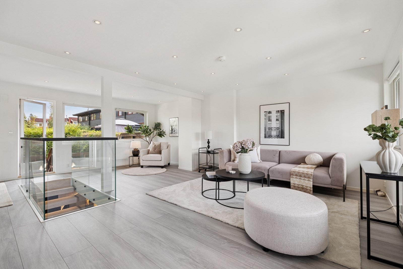 Stuen har god plass til både sofagruppe og spisestue, og deles naturlig inn i soner ved hjelp av den stilrene åpne trappen med glassrekkverk. Galleribilde