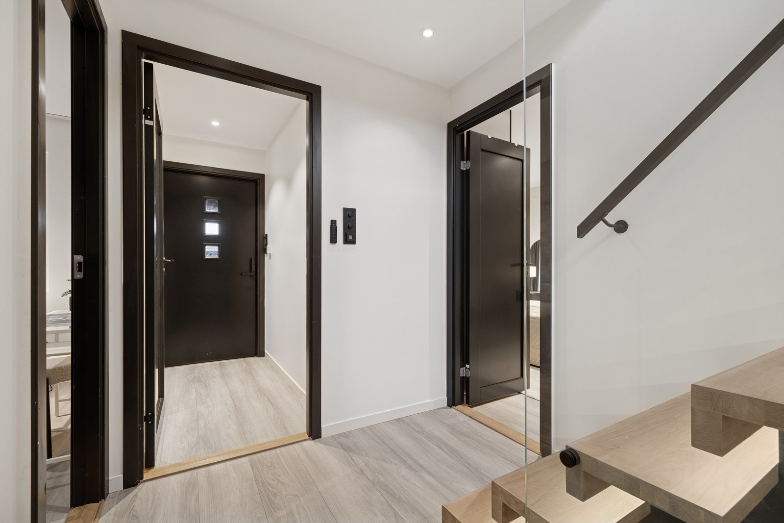 Innenfor døren ønsker en lys entré/hall velkommen inn. En sort ytterdør med glassfelt slipper inn naturlig dagslys, og gir rommet en behagelig atmosfære. Galleribilde