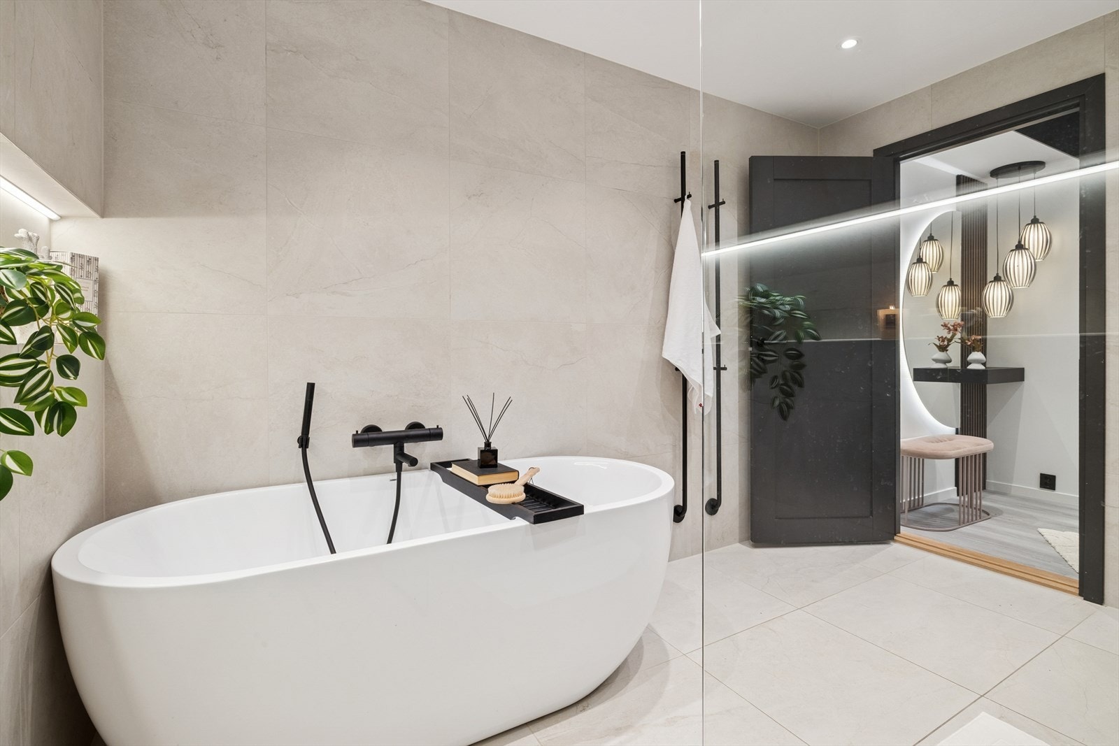 Badet er helfliset med lyse, elegante fliser som gir et tidløst og moderne uttrykk. Galleribilde