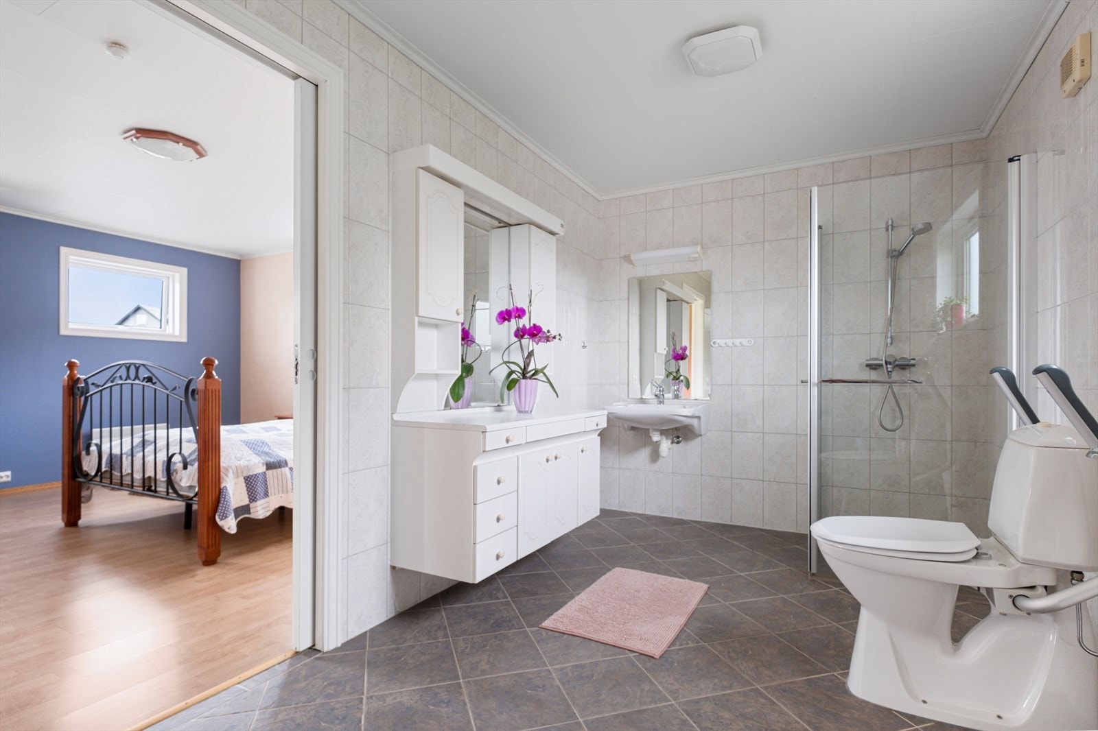 Romslig og pent bad med fliser på gulv og vegg. Galleribilde