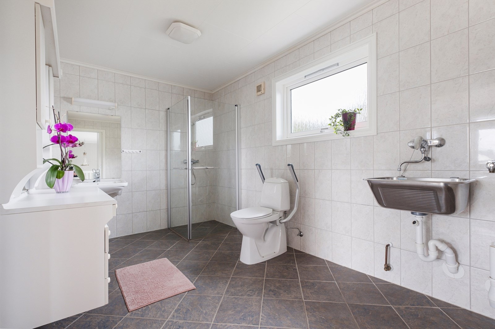 Romslig og pent bad med fliser på gulv og vegg. Galleribilde