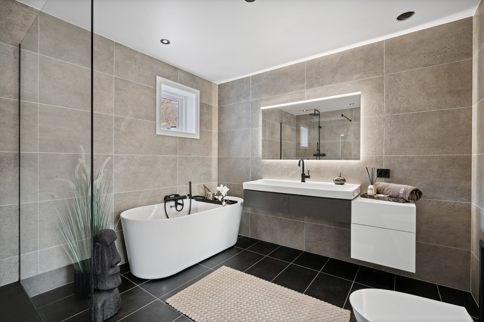 Delikat bad med innredning med nedfelt servant, toalett, badekar og dusjvegger/hjørne. Galleribilde