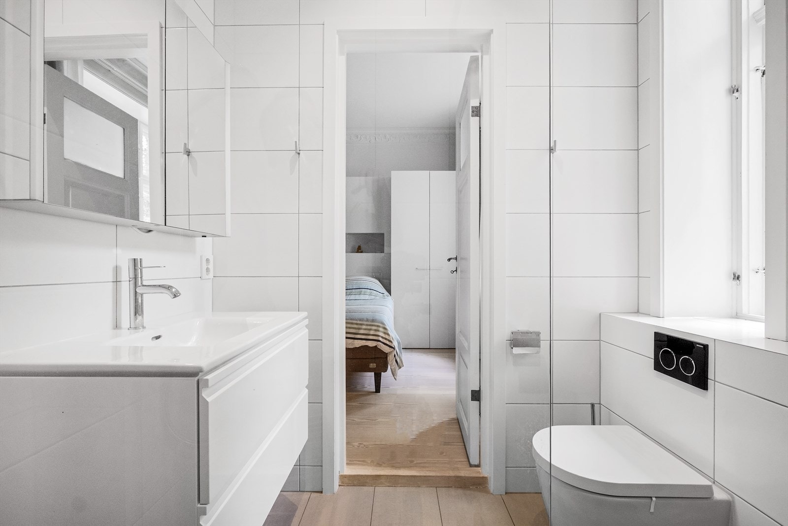 Vegghengt toalett med skuffer og speilskap som gir praktisk oppbevaring. Galleribilde