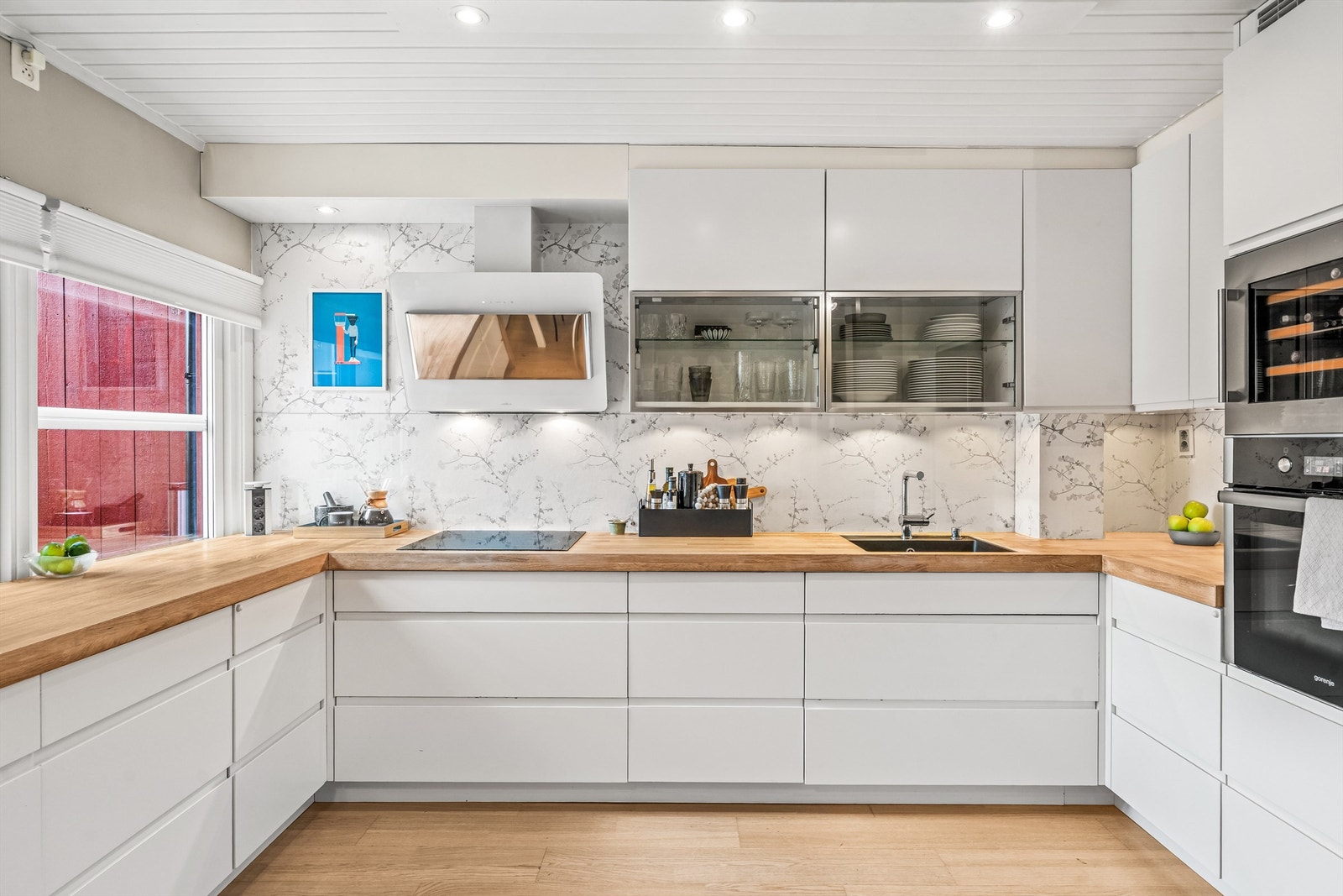 Innredningen består av slette, hvite fronter som gir et tidløst uttrykk, kombinert med en benkeplate i heltre. Galleribilde