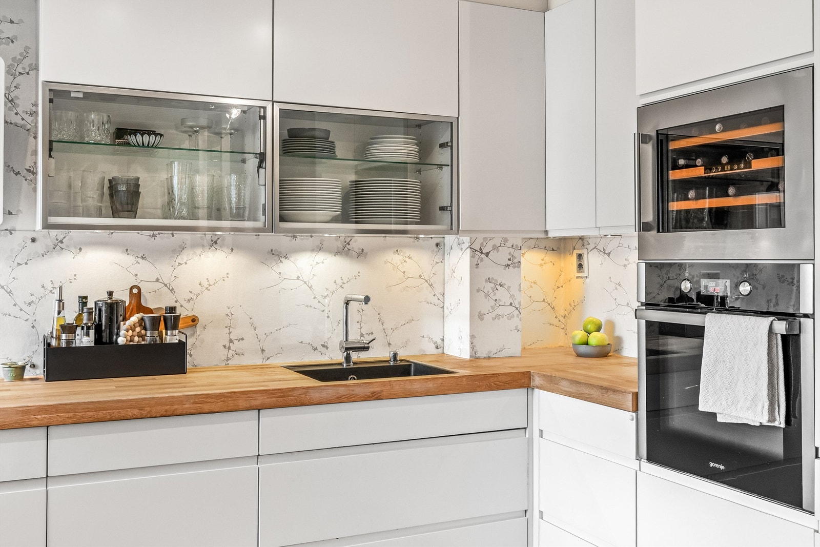 Kjøkkenet har integrerte hvitevarer som induksjonstopp, stekeovn, vinskap, oppvaskmaskin og kjøleskap, samt avtrekksvifte over koketoppen Galleribilde