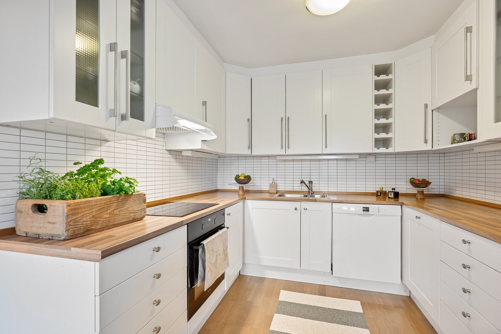 Kjøkkenet har en praktisk utforming langs tre vegger, og bra med skap- og benkeplass. Galleribilde