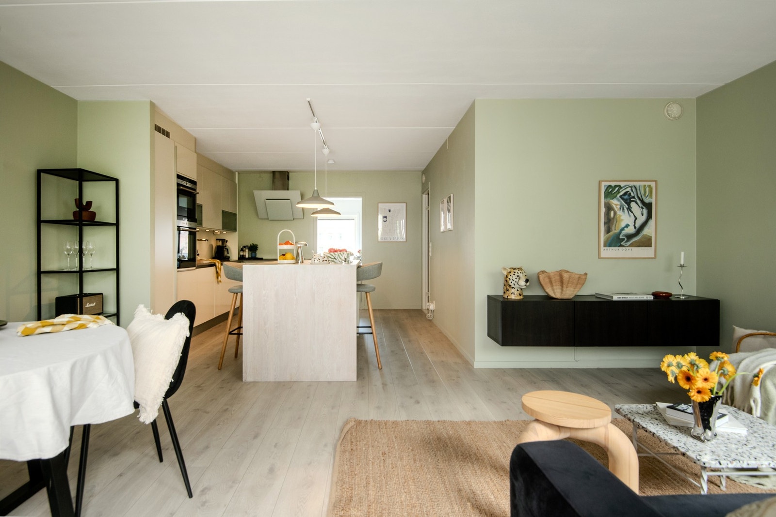 Den åpne løsningen mot kjøkkenet gir en sosial og luftig atmosfære, perfekt til både hverdags og hyggelige sammenkomster. Galleribilde