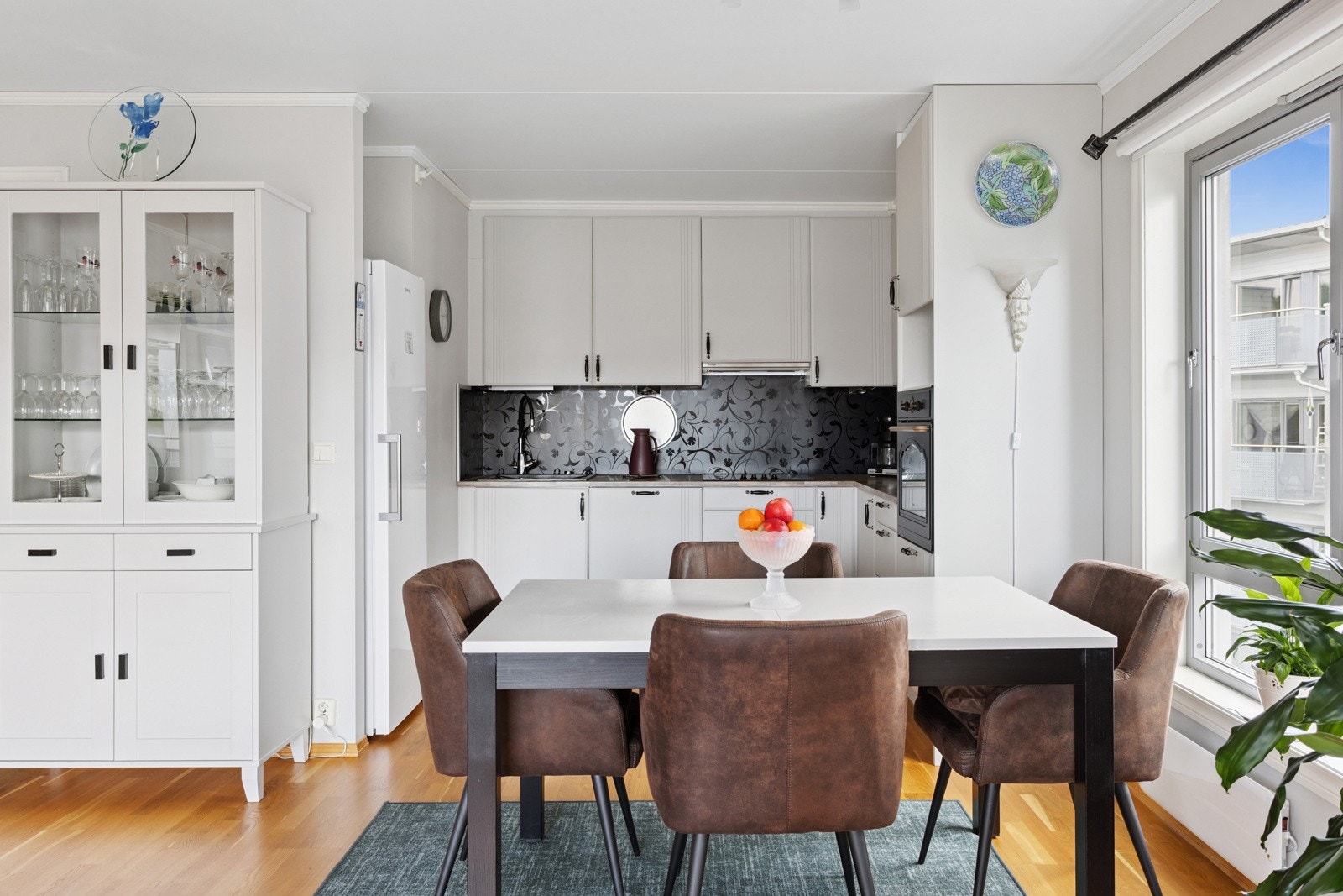 Kjøkkeninnredning med fabrikklakkerte fronter m/profilspor og laminat benkeplate m/plater over. Galleribilde