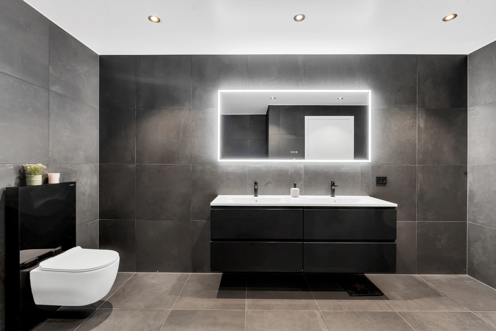 Svært lekkert, komplett flislagt bad i mørke storformatfliser. Galleribilde