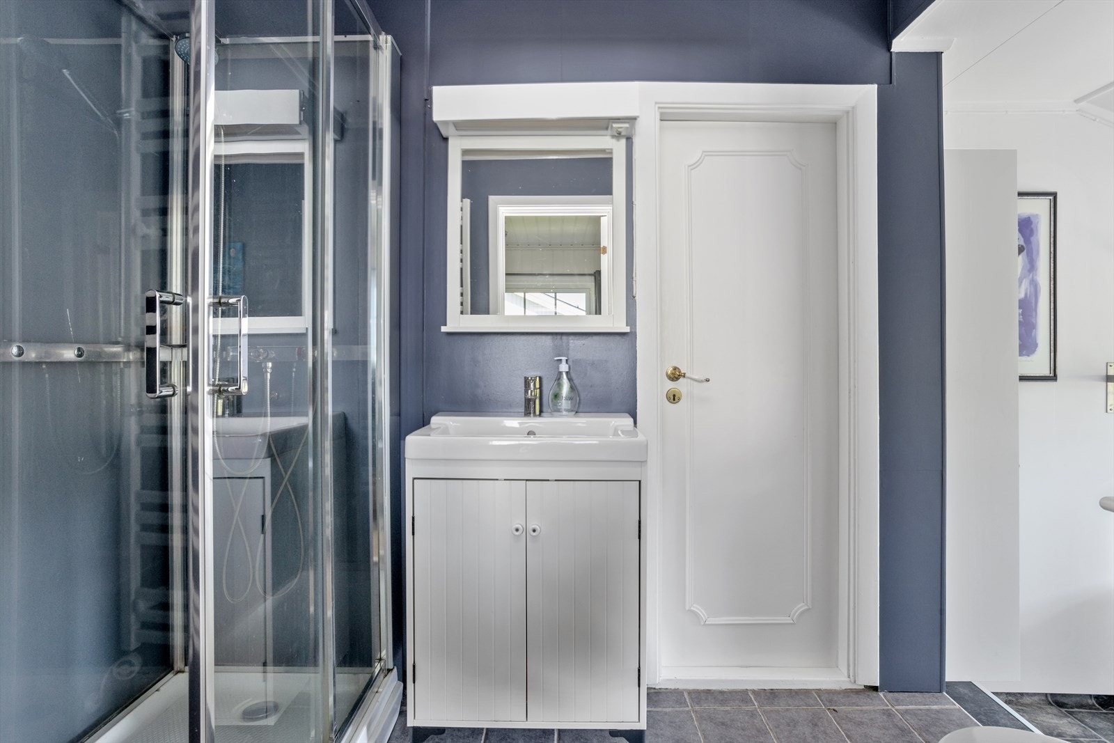 Badet hat overflater som består av fliser og vinylbelegg på gulv, malte slette plater på vegger og malte plater i himling. Galleribilde