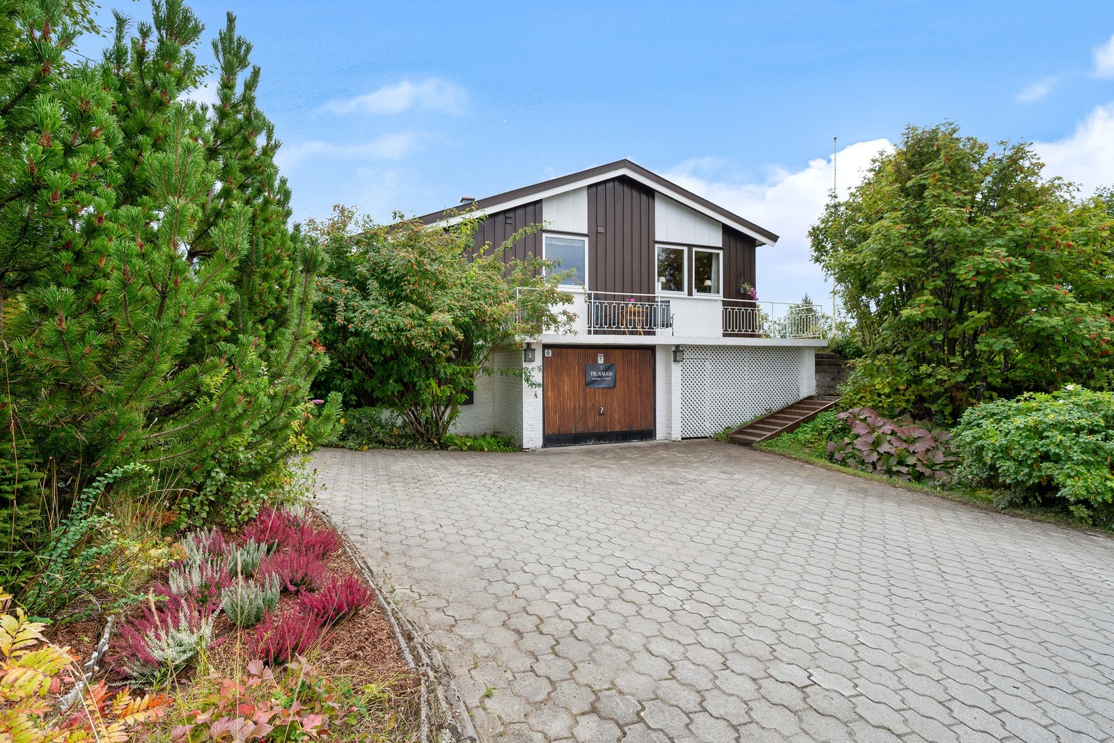 Stor gårdsplass med belegningsstein og garasje gir parkering for flere biler Galleribilde