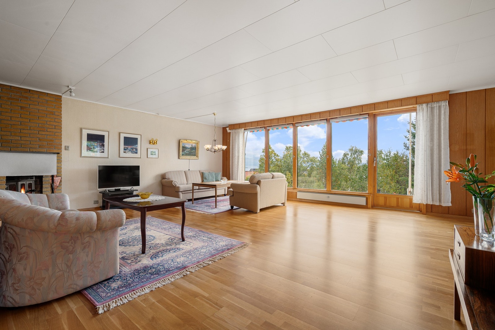 Her ønskes vi velkommen av en stor og luftig stue med store vindusflater langs hele veggen! Galleribilde