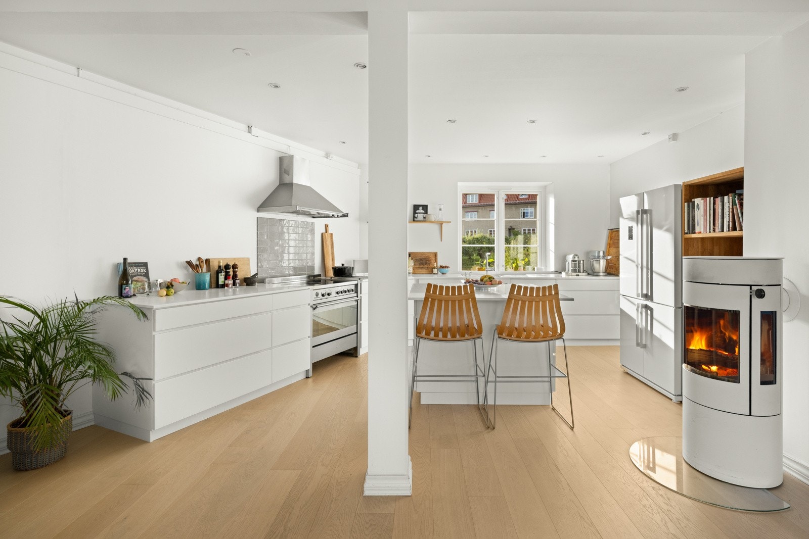 Et romslig og stilrent kjøkkenrom med en praktisk kjøkkenøy med sitteplass til 4 personer. Kjøkkenet ble innredet med en lekker hvit innredning fra Kvik Mano XXL, fra 2017. Galleribilde