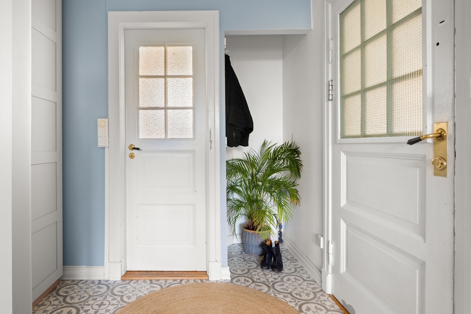 Et praktisk inngangsparti med flislagt gulv med varmekabler. Garderobeskap i en av nisjene. Galleribilde