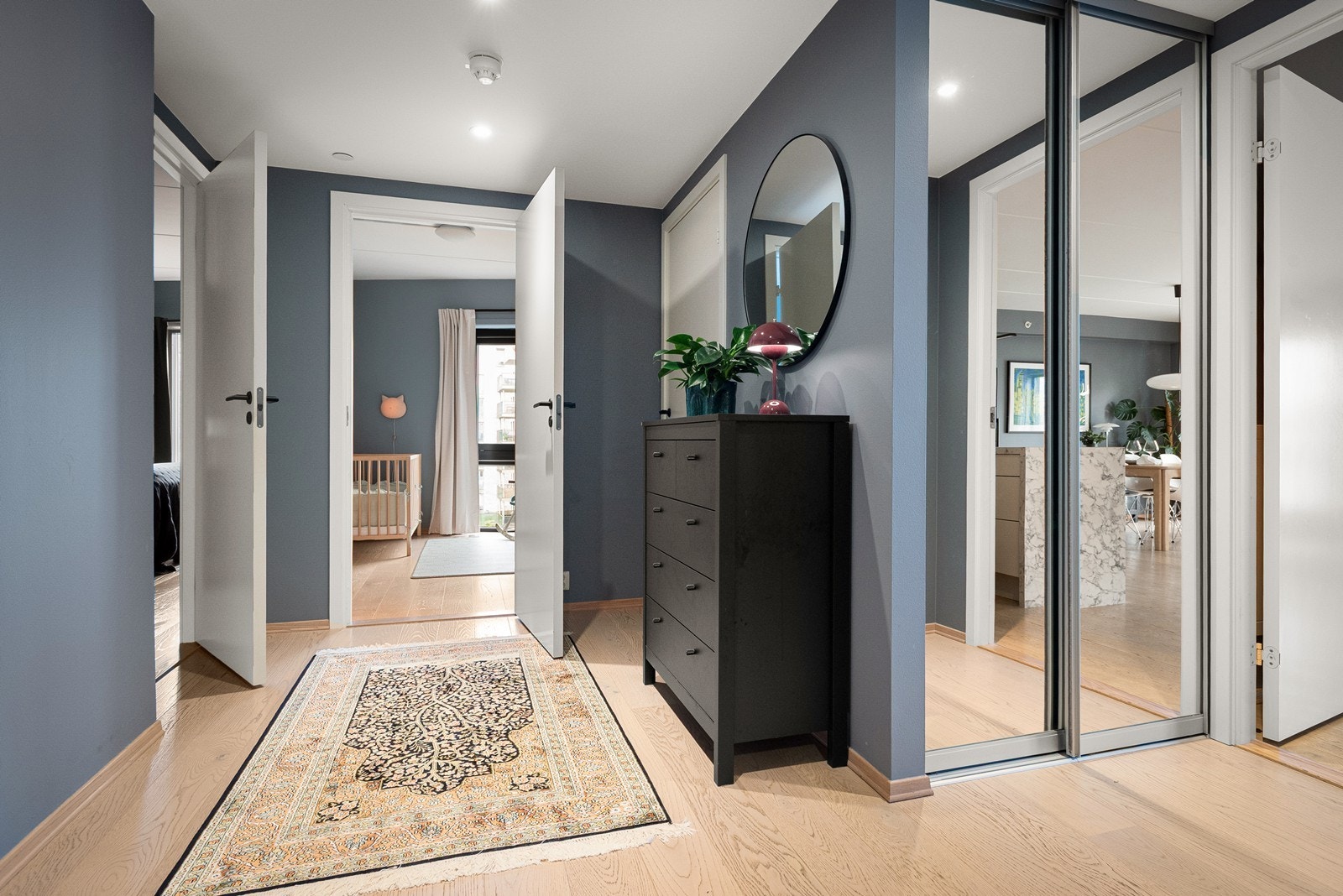 Romslig og innbydende entré med god plass til oppbevaring av yttertøy og sko i skyvedørsgarderoben Galleribilde