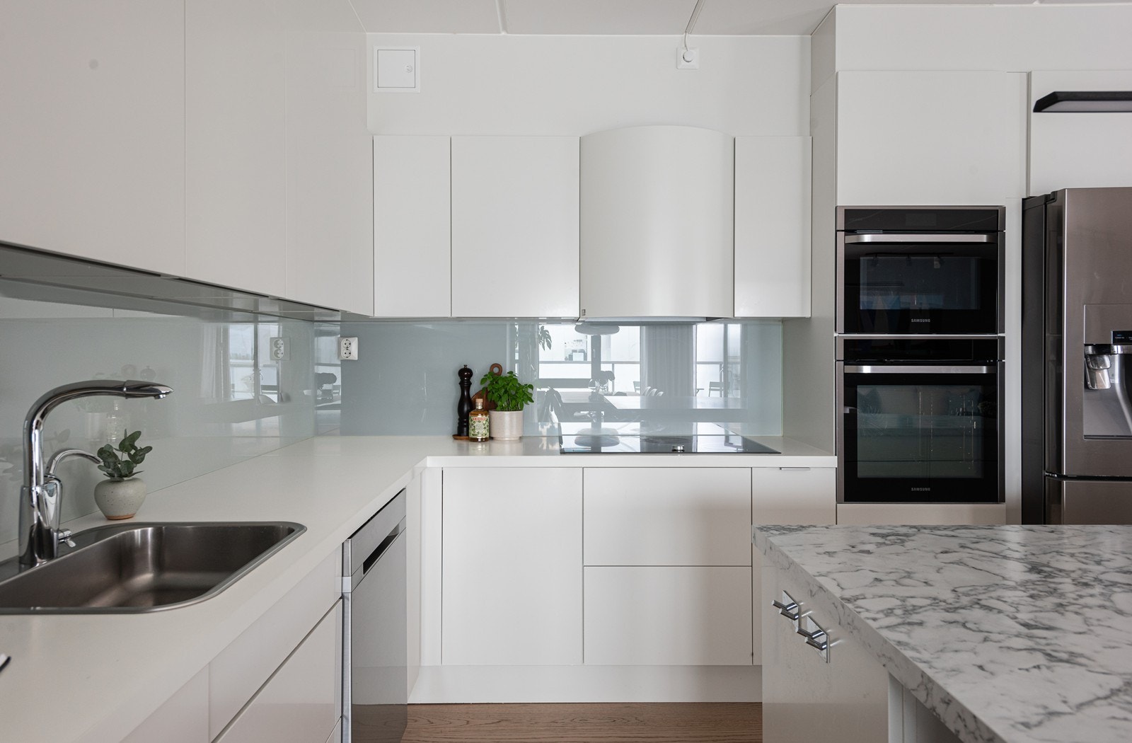 Kjøkkenet er utstyrt med hvitevarer fra Samsung, inkludert en integrert induksjonstopp, en kombinert stekeovn med dampfunksjon og en kombinert stekeovn med mikrobølgeovn Galleribilde