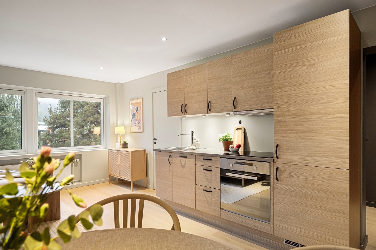 Innredning med glatte skapfronter i brun utførelse, benkeplate i laminat, nedfelt oppvaskkum og ett-greps armatur Galleribilde