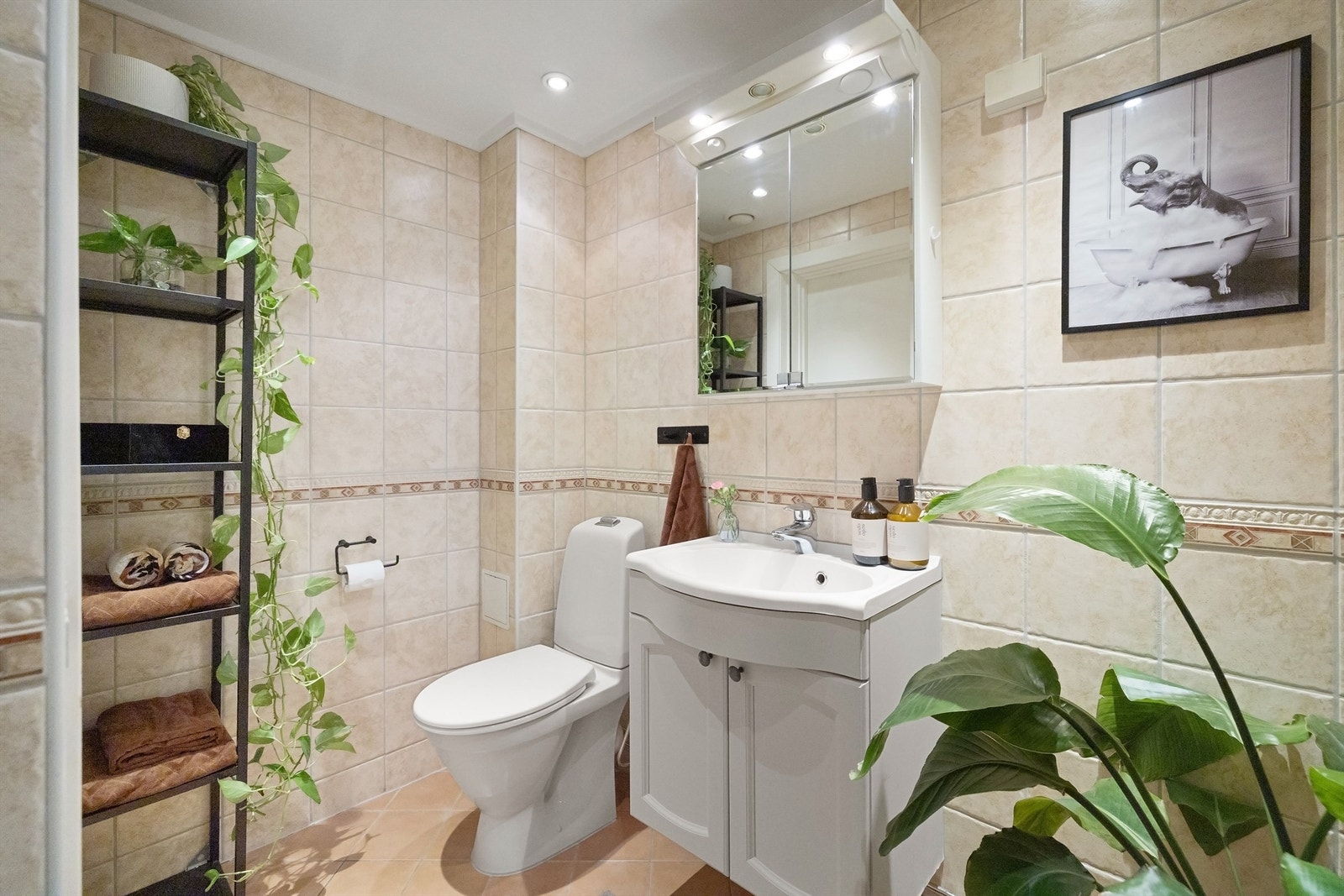 Badet er utstyrt med gulvstående toalett og dusjhjørne med innfellbare glassdører i glass Galleribilde