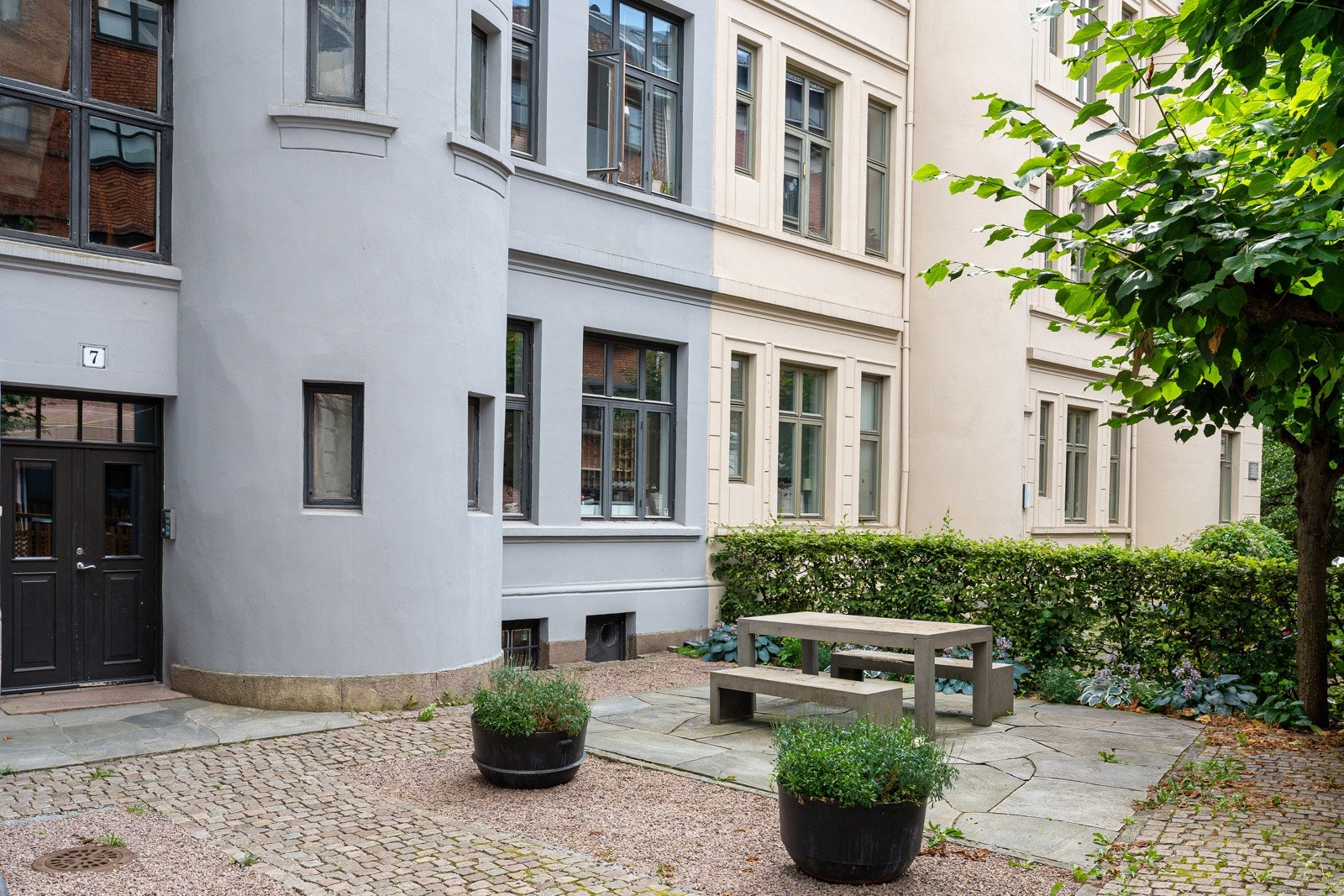 Opparbeidet bakgård med sittegrupper og beplantning Galleribilde