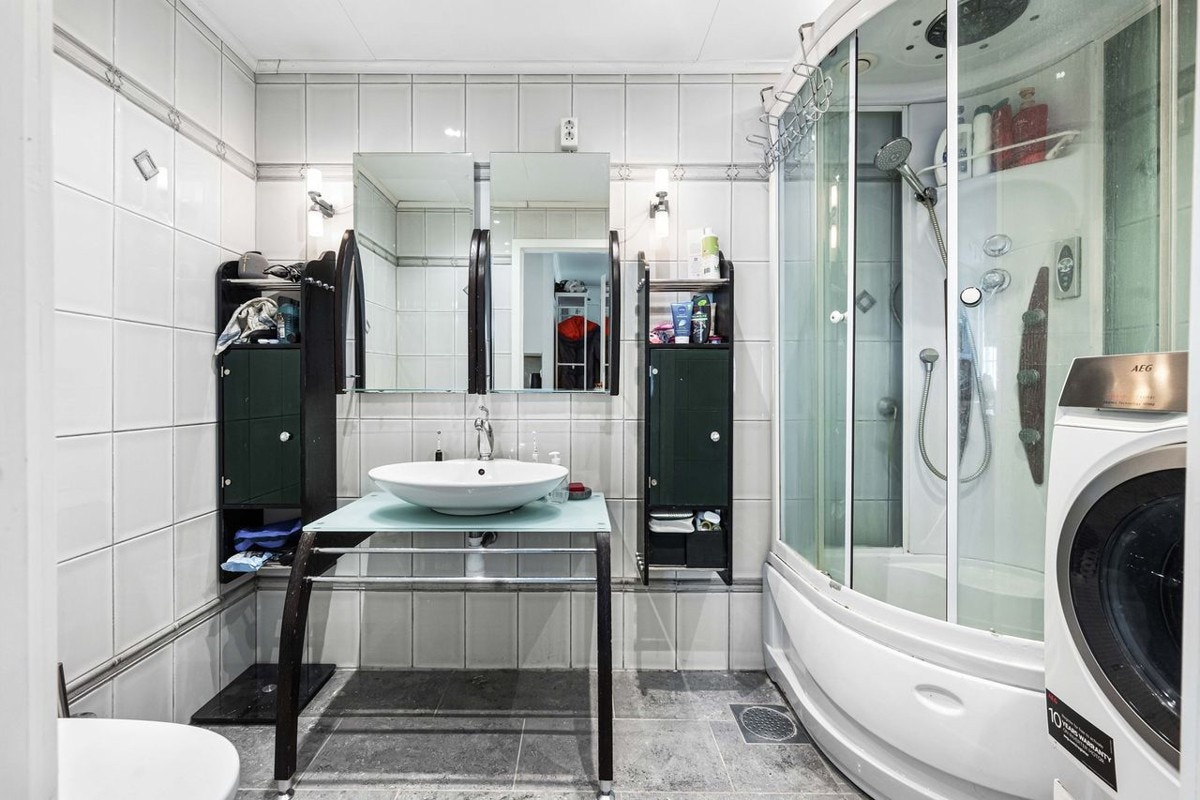Badet er innredet med dusjkabinett, toalett, servant og opplegg for vaskemaskin. Galleribilde