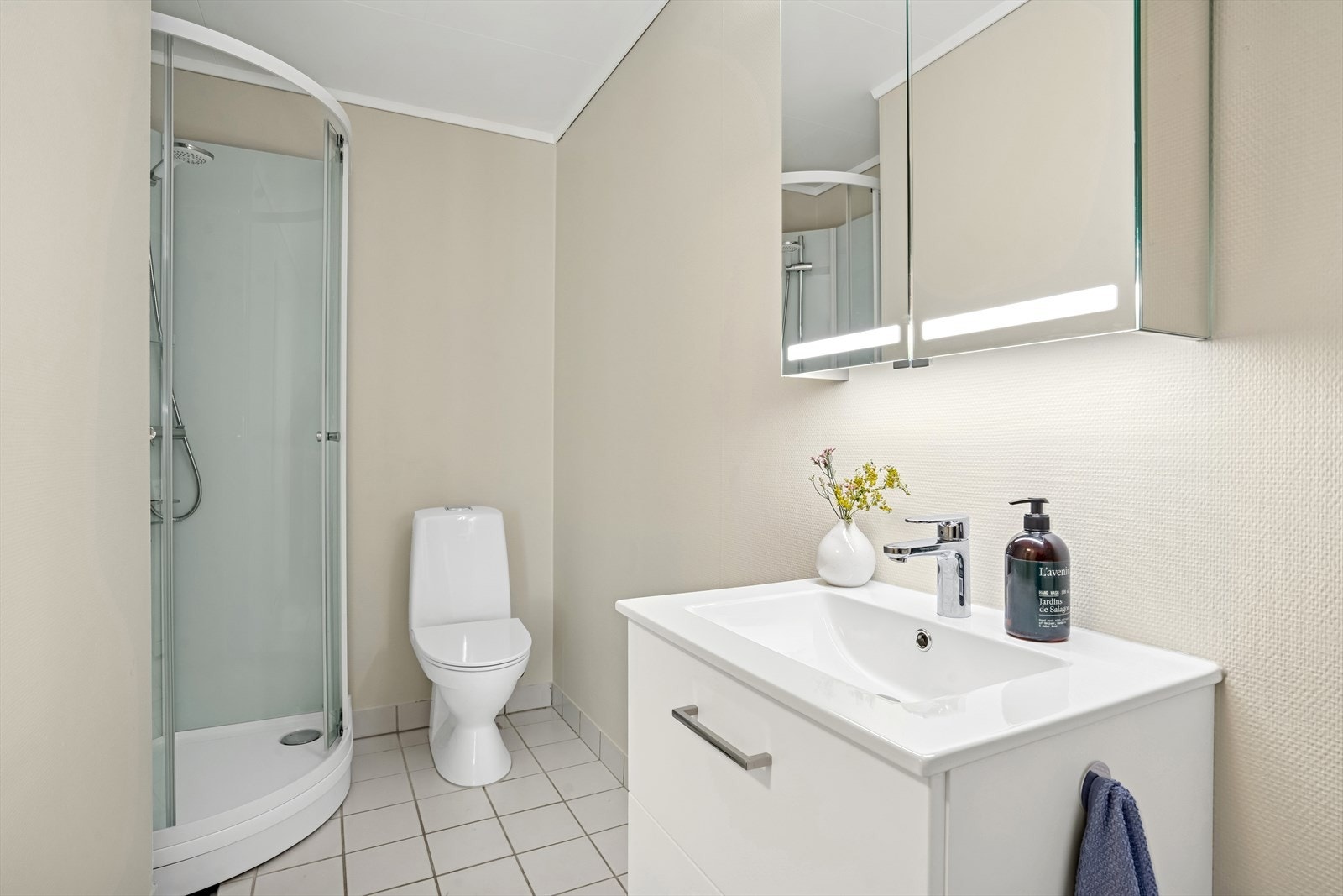 Badet er innredet med servantskap med ett-greps blandebatteri, speilskap med lys, gulvstående toalett og dusjkabinett. Galleribilde
