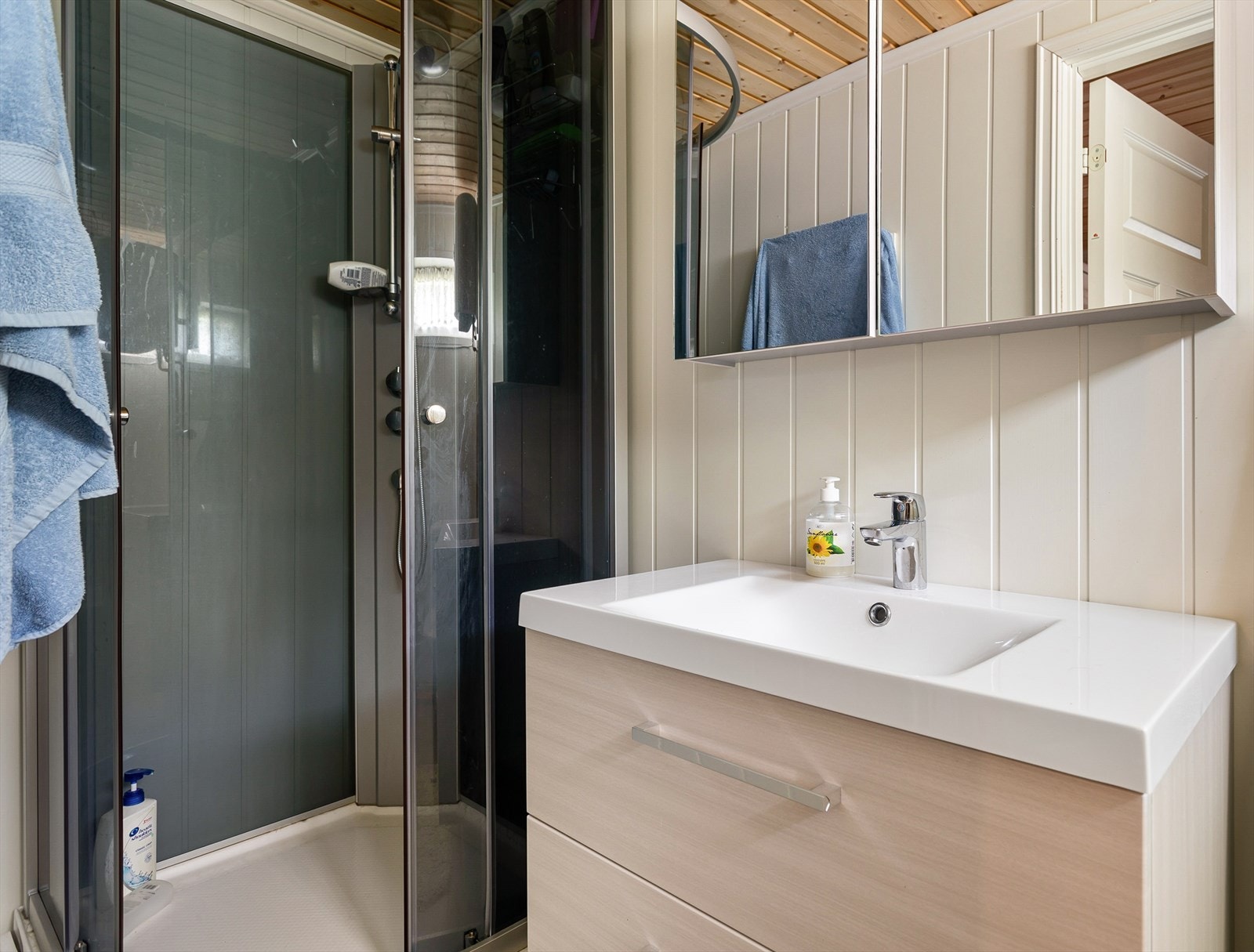 Bad i boenheten, innredet med dusjkabinett og servant på innredning. Galleribilde