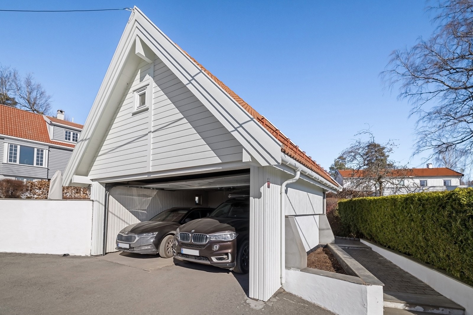 Dobbelgarasje med automatiske vippeport, og stort lagringsloft med utvendig atkomst via trapp i bakkant av garasjen. Galleribilde