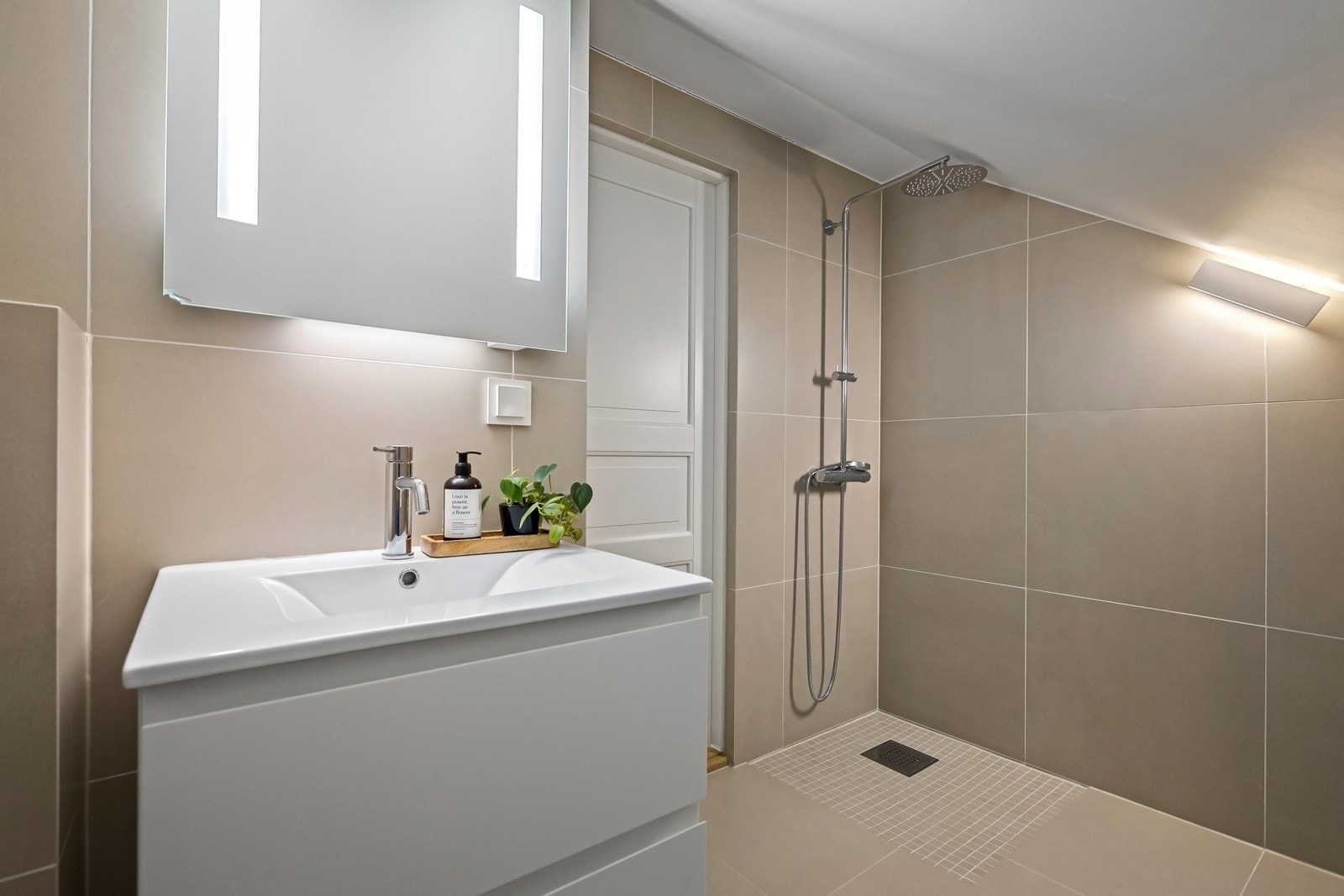 Baderom i loftsetasjen, innredet med dusjhjørne, servant med skuff, og toalett. Galleribilde