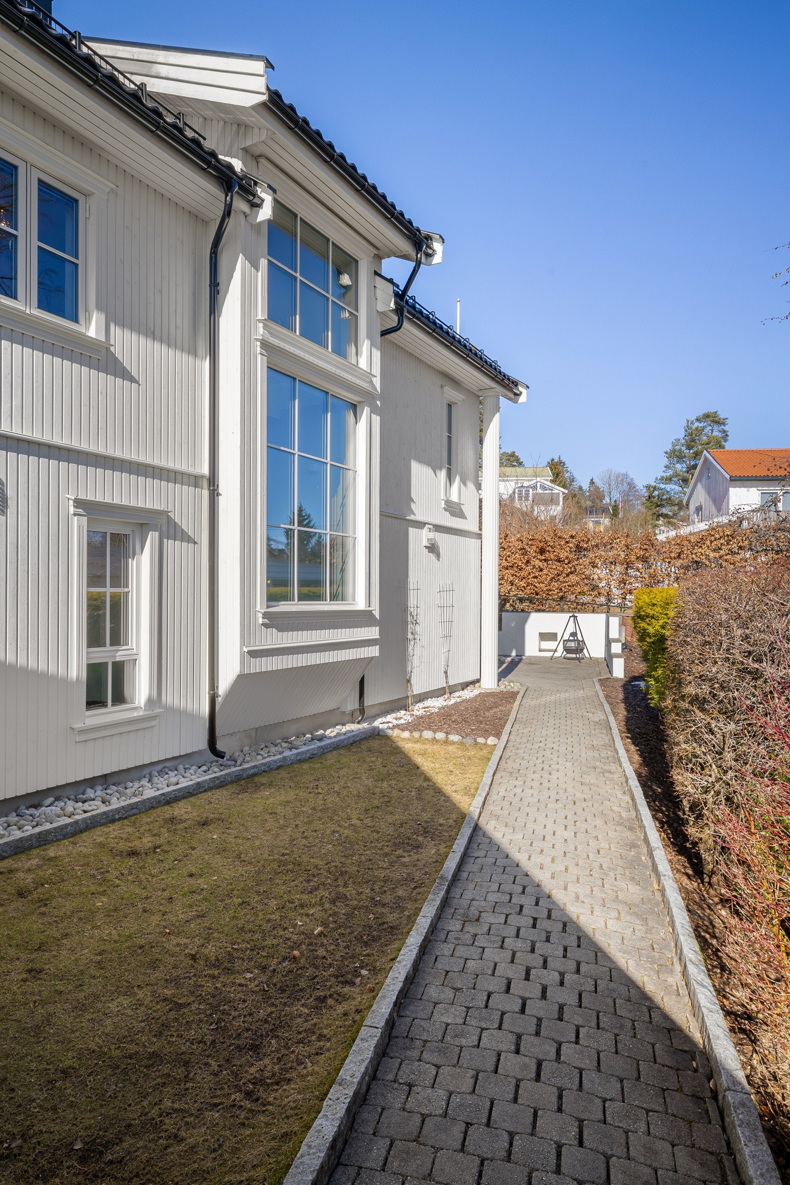 Tomten er pent opparbeidet med steinlagte gangveier og granittstein. Kullsvart glassert takstein fra Zanda. Galleribilde