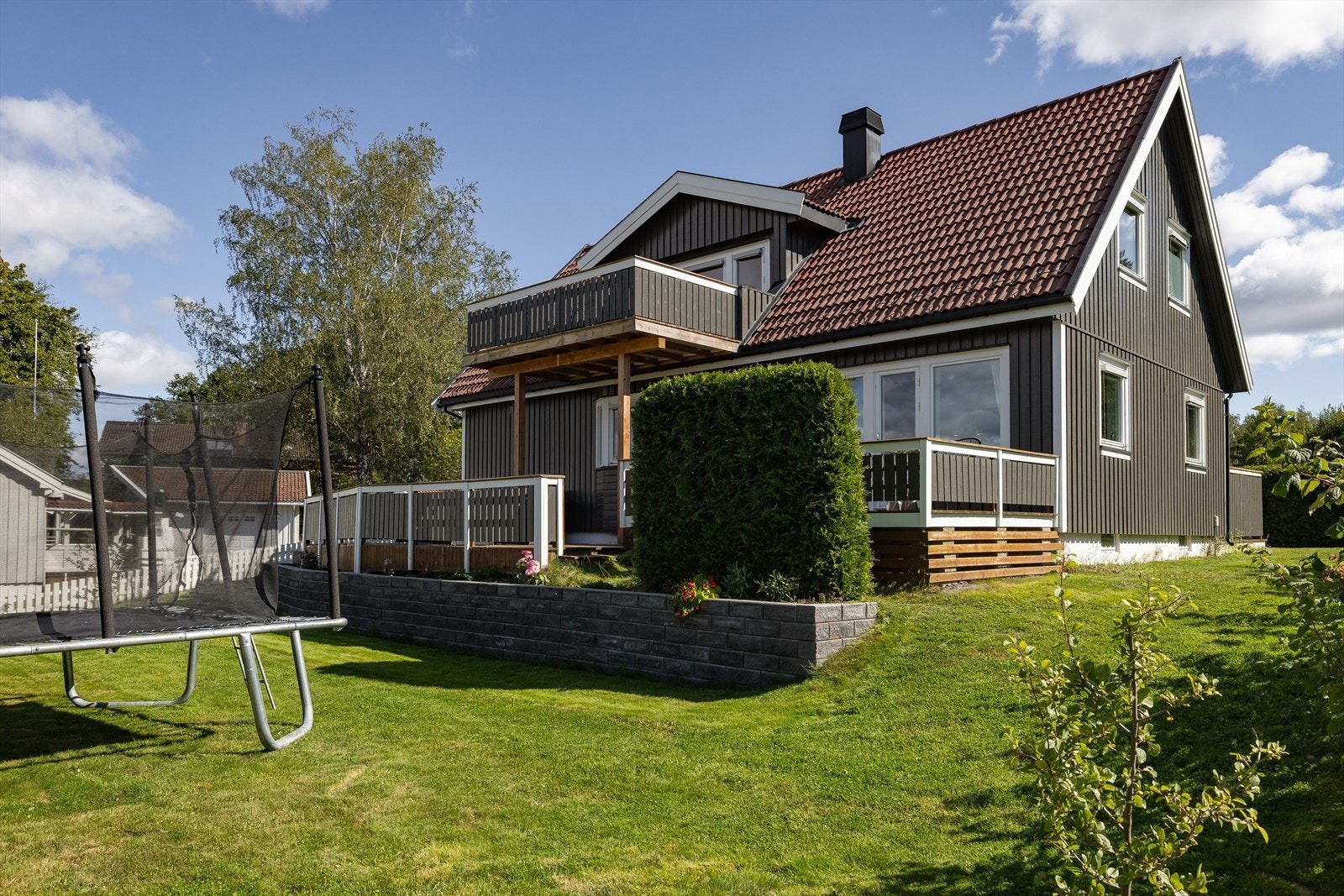 Eiendommen har en pent opparbeidet hage med støttemur, blomsterbed og diverse beplantning. Galleribilde
